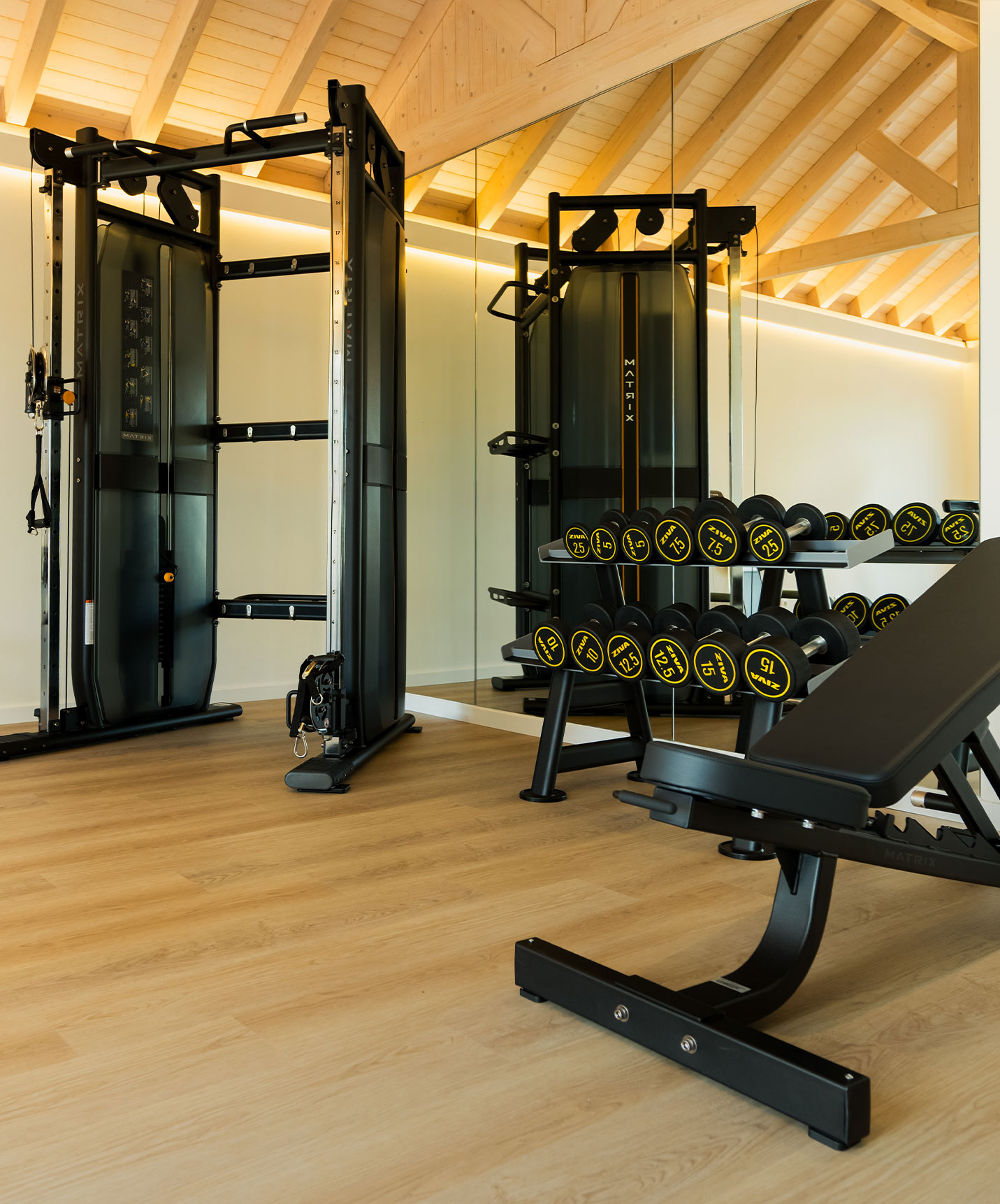 Salle de sport équipée avec une machine de musculation et des poids dans les villas du Pestana Comporta Village Residences