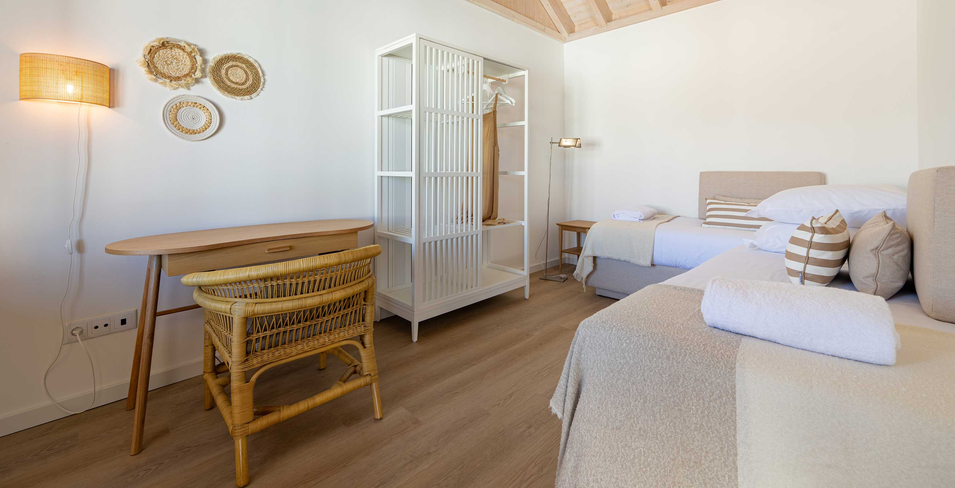 La Premium Villa du Pestana Comporta Village Residences dispose d'une chambre avec lit, table et chaise en osier