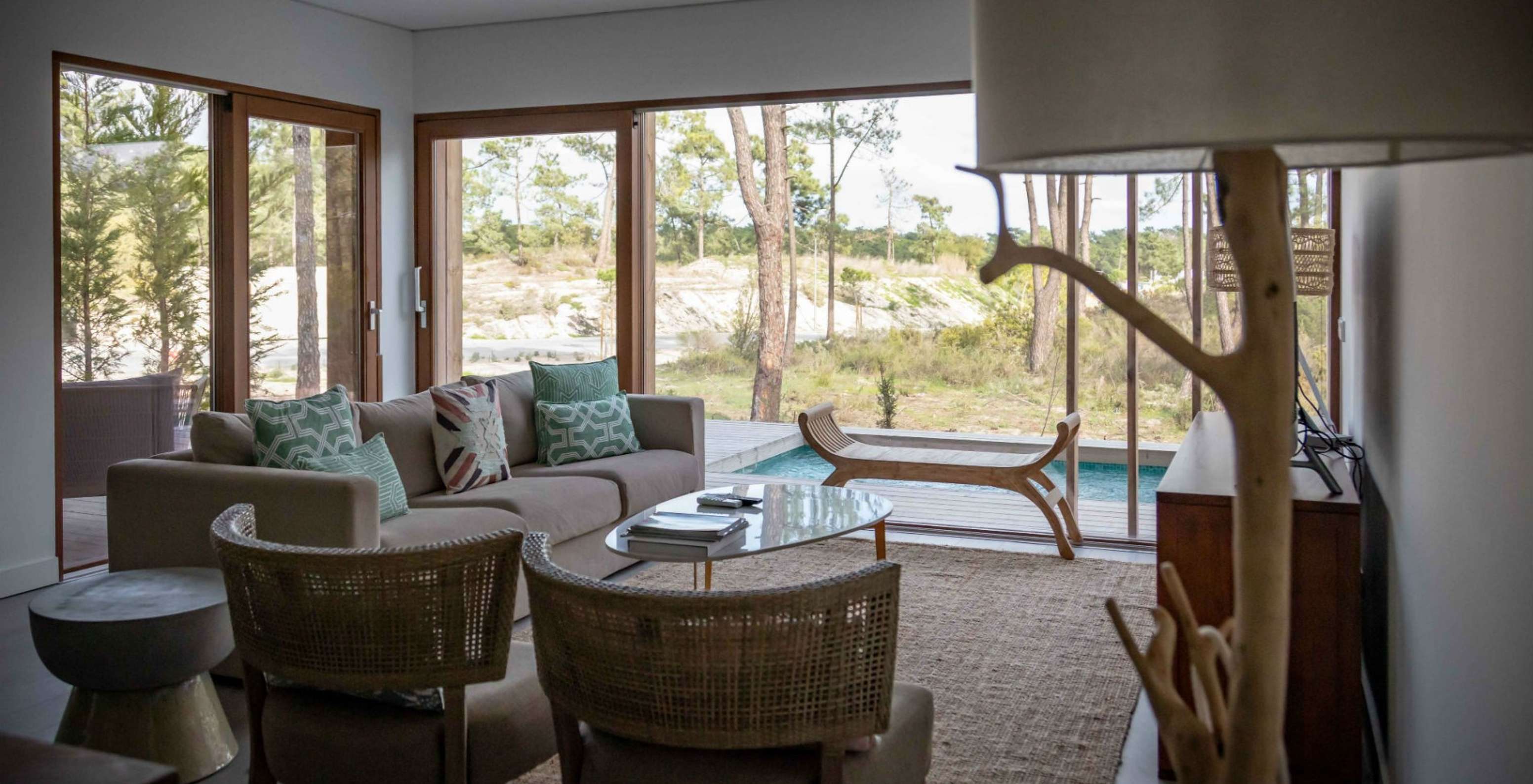 L'appartement Eco Village rez-de-chaussée Vues du Pestana Tróia Eco Resort a une salle avec canapé et vue sur la piscine