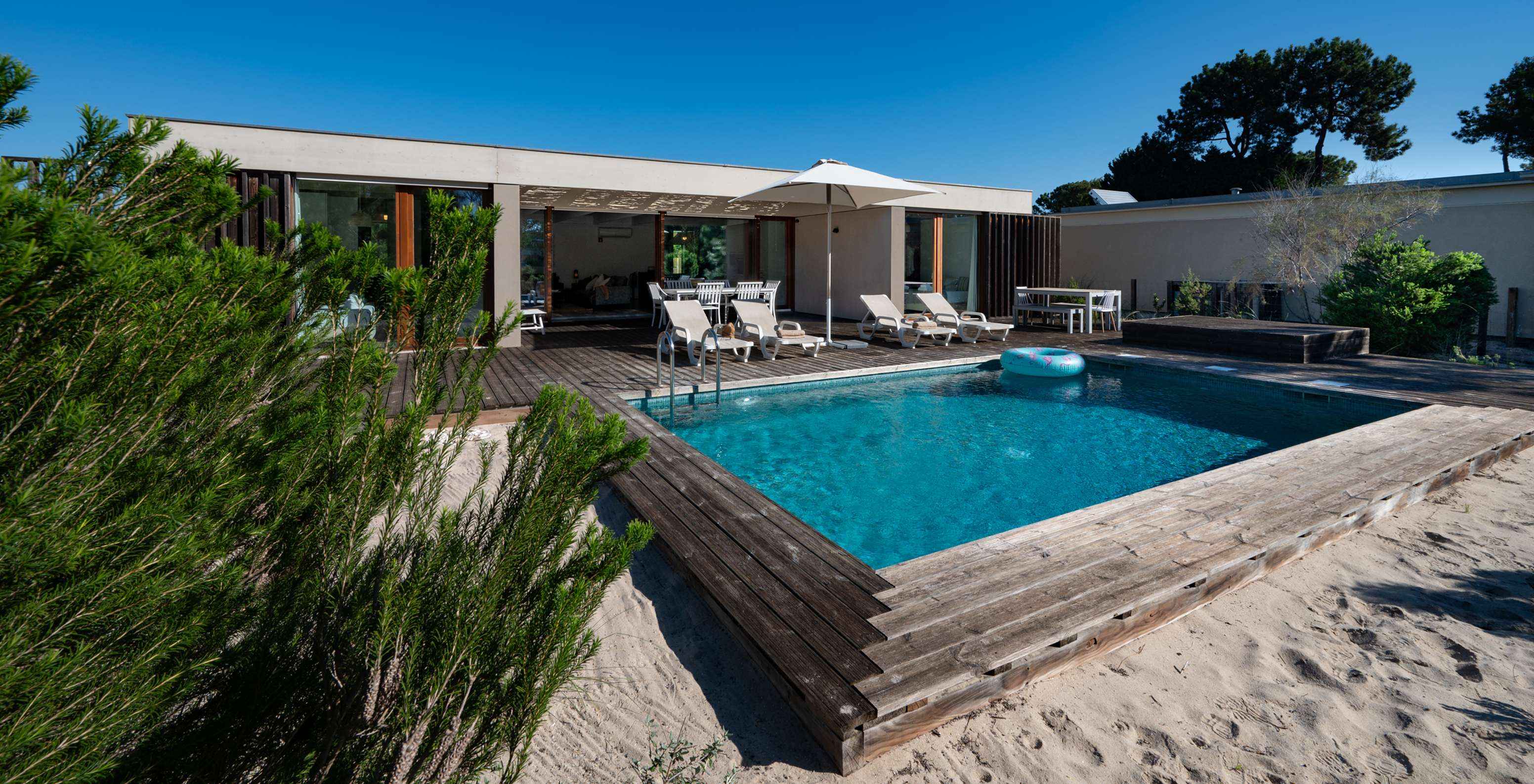 La Beach Villa avec piscine privée du Pestana Tróia Eco Resort a plusieurs chaises longues, un parasol et une bouée