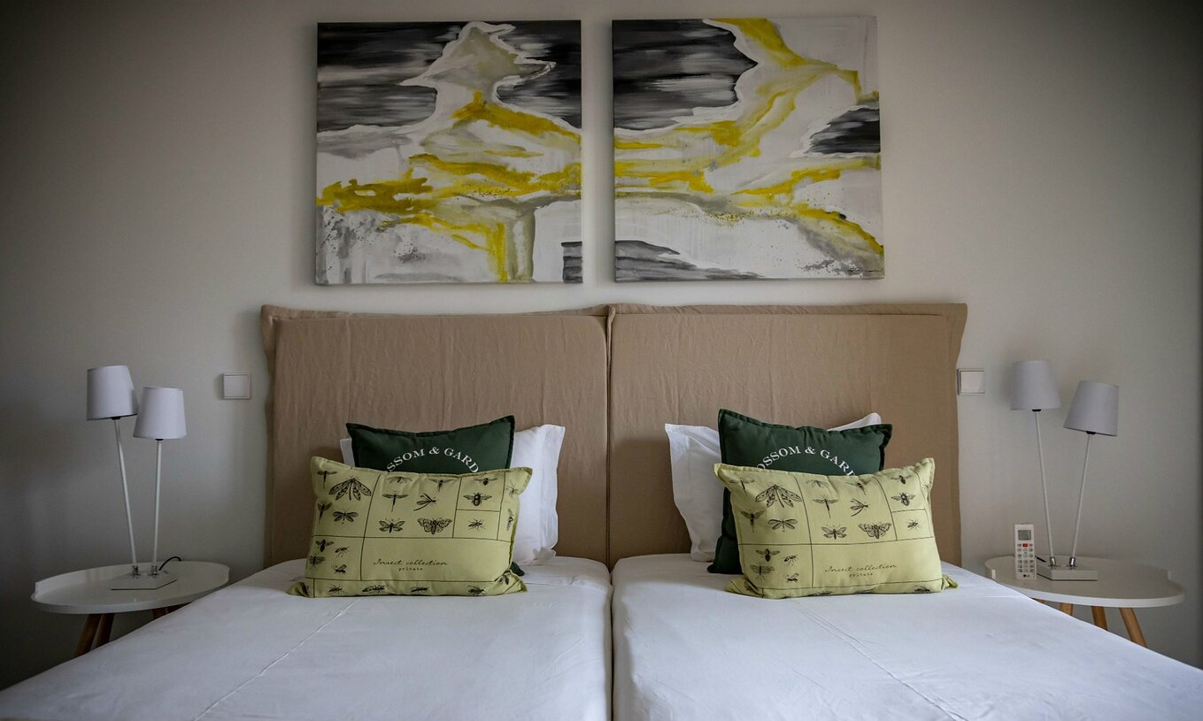 L'appartement Eco Village rez-de-chaussée du Pestana Tróia Eco Resort a deux lits jumeaux et des tableaux au mur