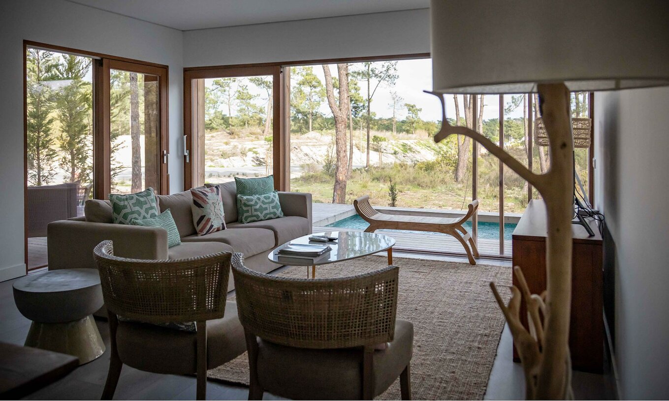 L'appartement Eco Village rez-de-chaussée Vues du Pestana Tróia Eco Resort a une salle avec canapé et vue sur la piscine