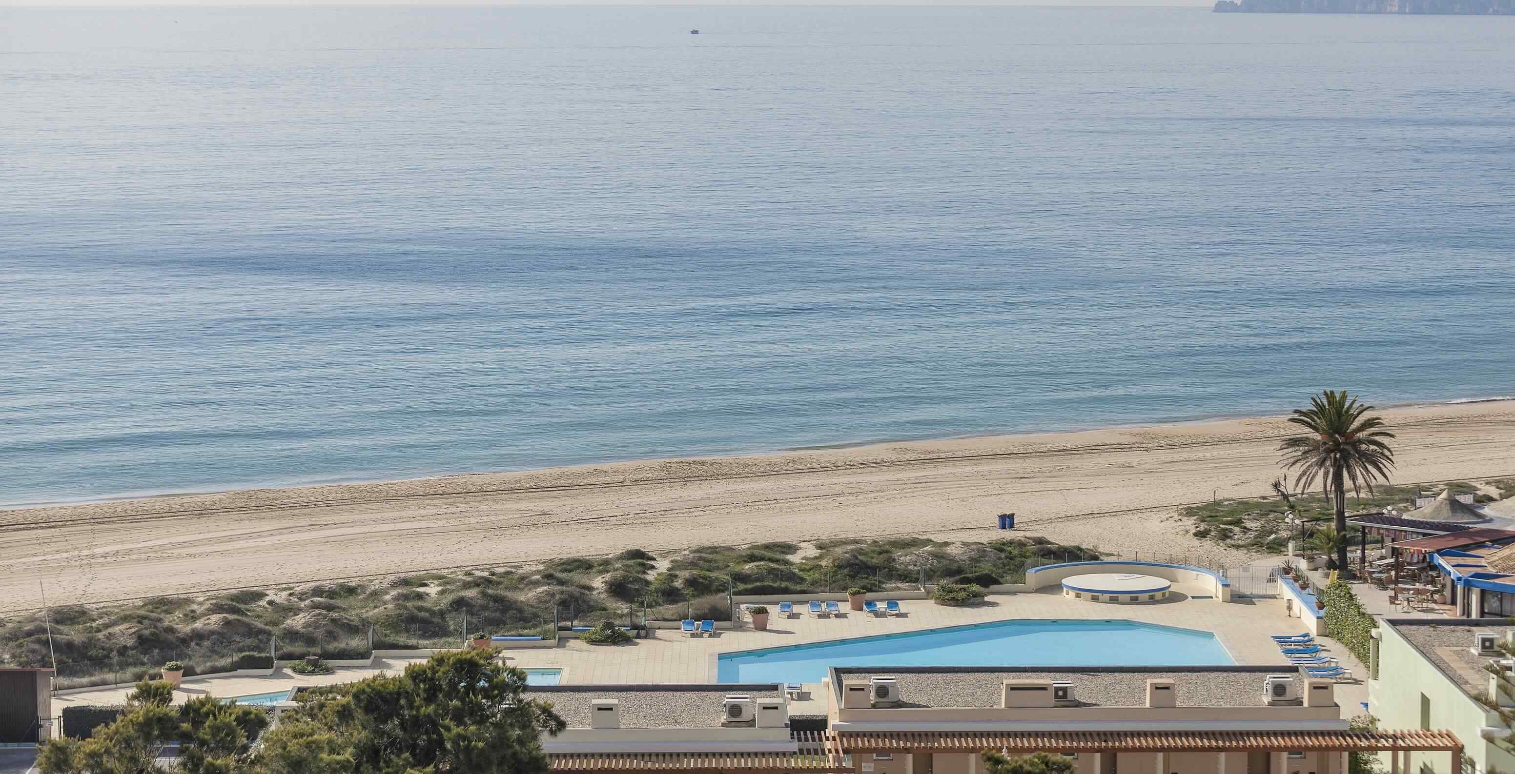 La plage d'Alvor, en Algarve, a du sable doré, une eau cristalline, une passerelle et des dunes