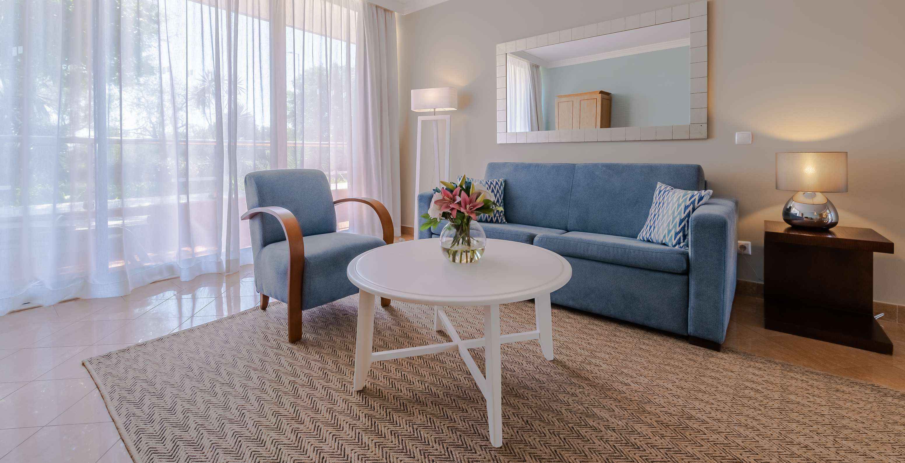 Le T1 - 1 Chambre du Pestana Alvor Park a un salon avec un canapé et un fauteuil bleus