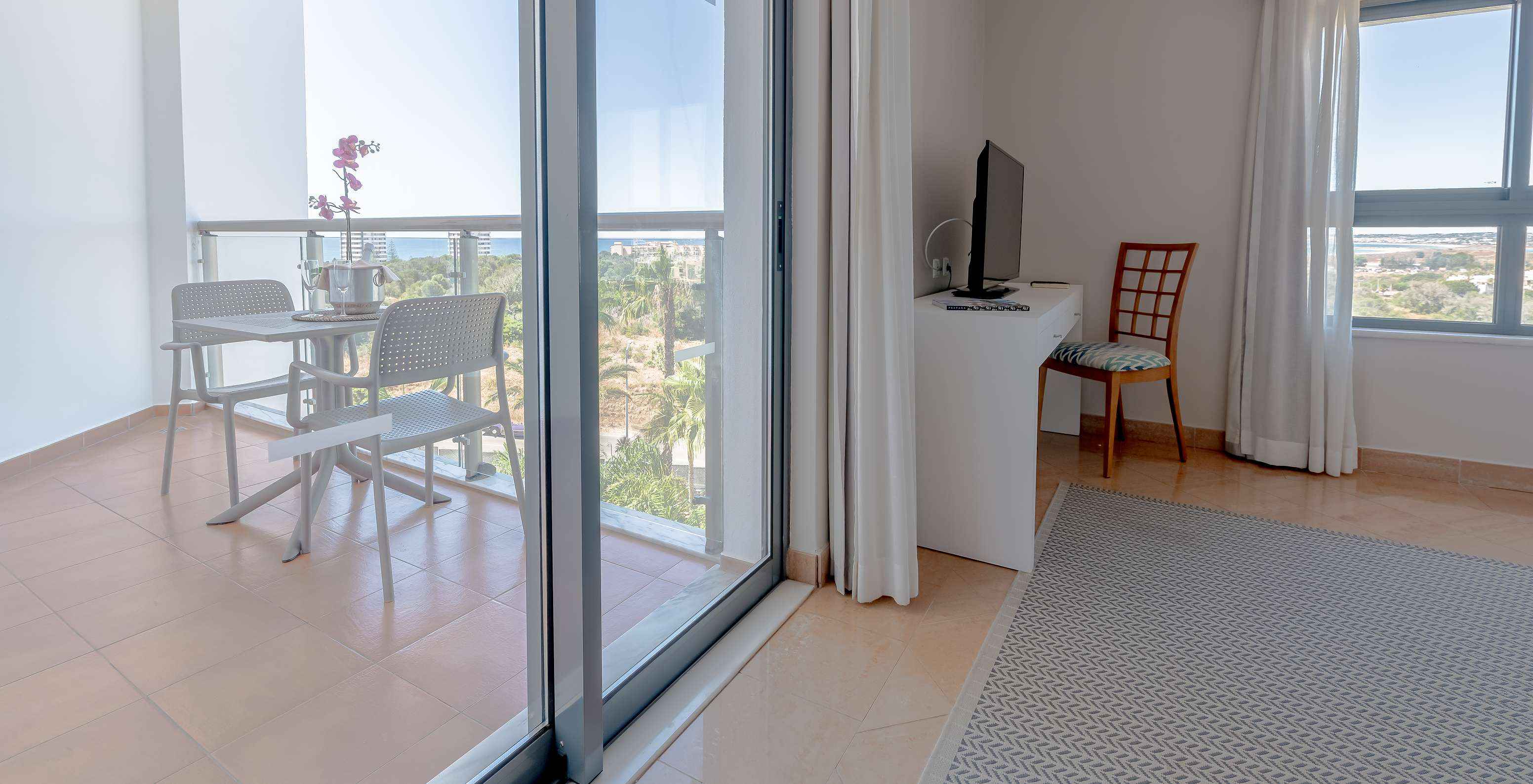 Le T0 - Studio du Pestana Alvor Park a balcon avec vue jardin et mer au fond, avec table et chaises