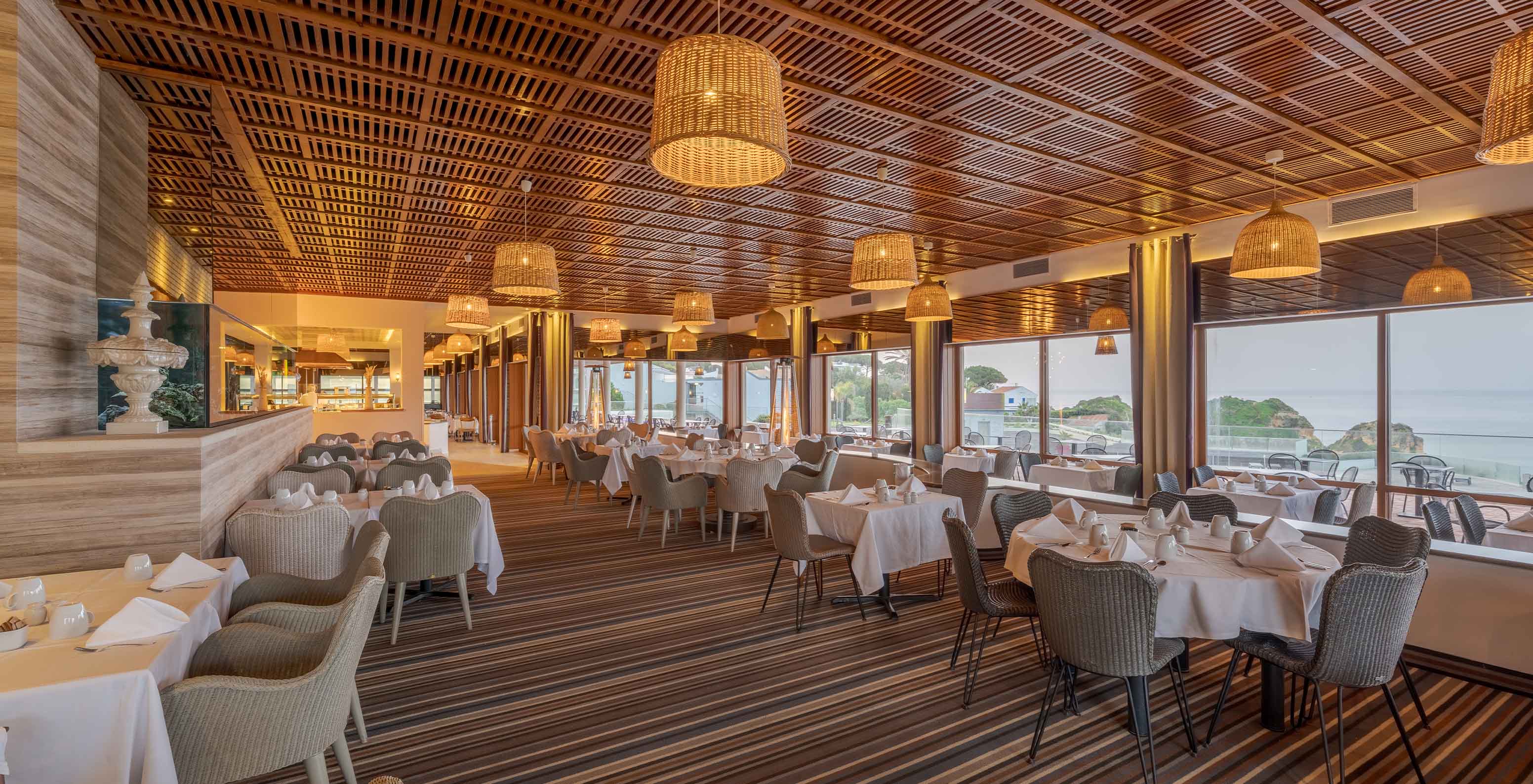 Le restaurant Almofariz, à l'Hôtel 5 étoiles en Algarve, a un plafond en bois, un aquarium et une vue sur la mer