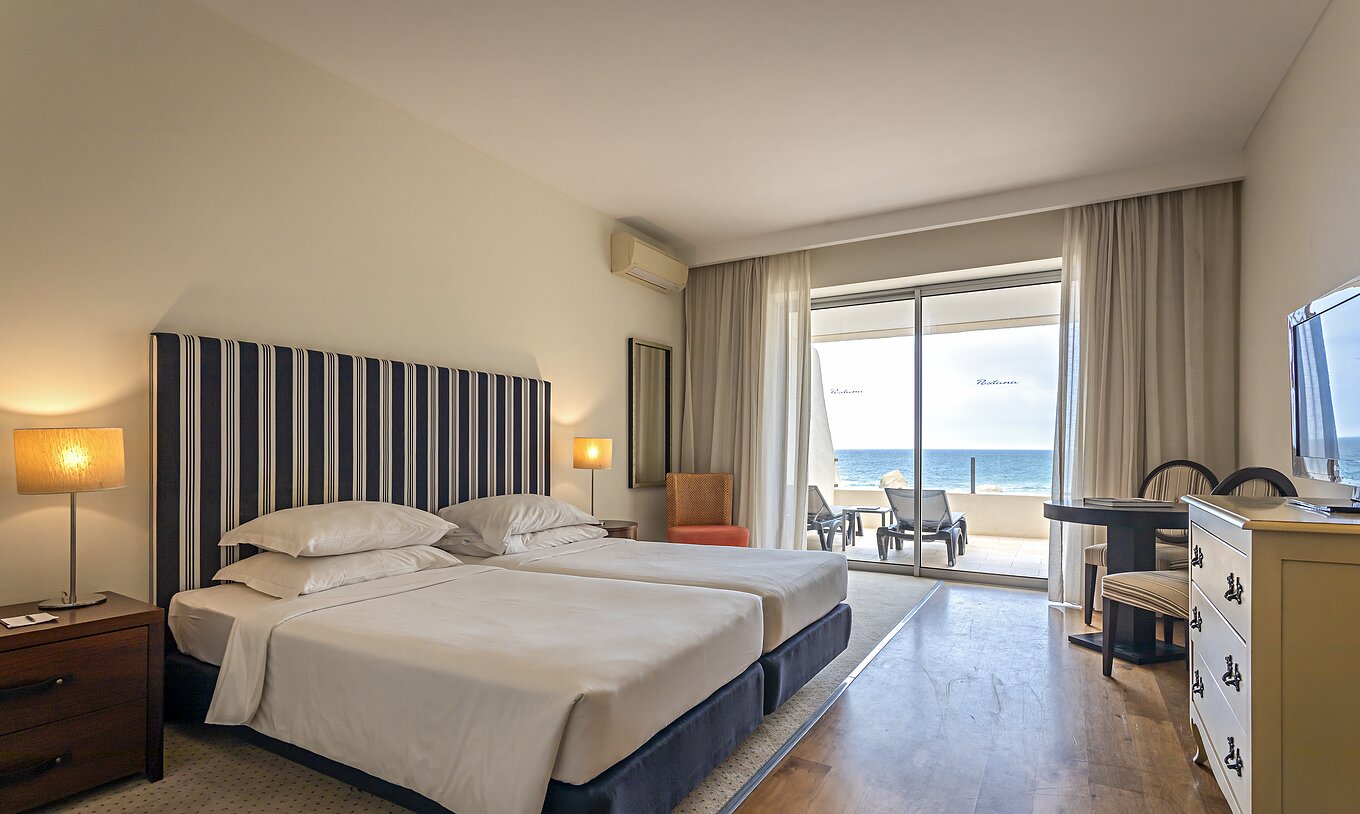 La Suite Cliff T1 du Pestana Alvor Praia offre une chambre double, un balcon avec transats et une superbe vue sur la mer