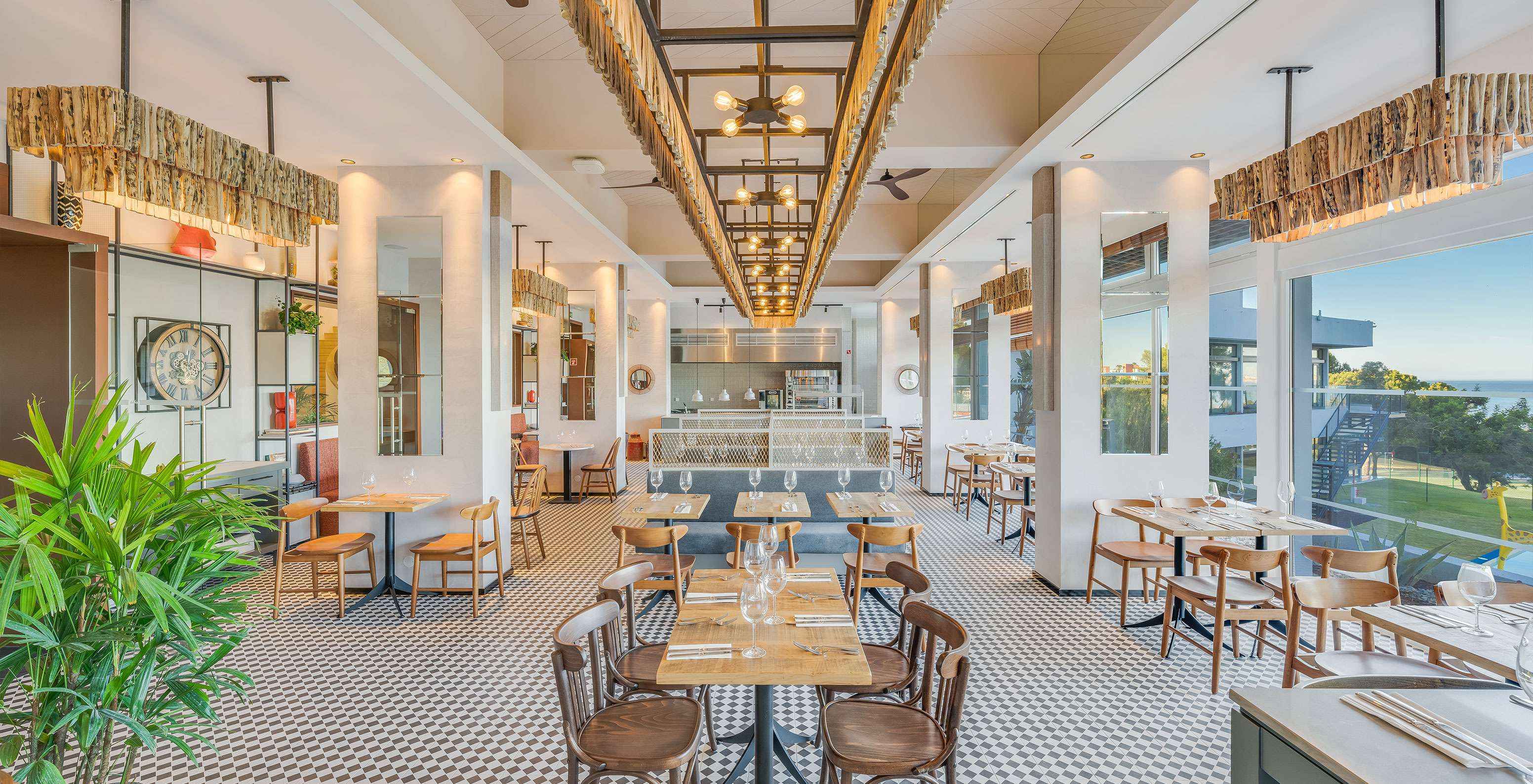 Le restaurant Fuego, à l'Hôtel Tout Inclus en Algarve, a une décoration moderne avec plusieurs tables donnant sur le jardin