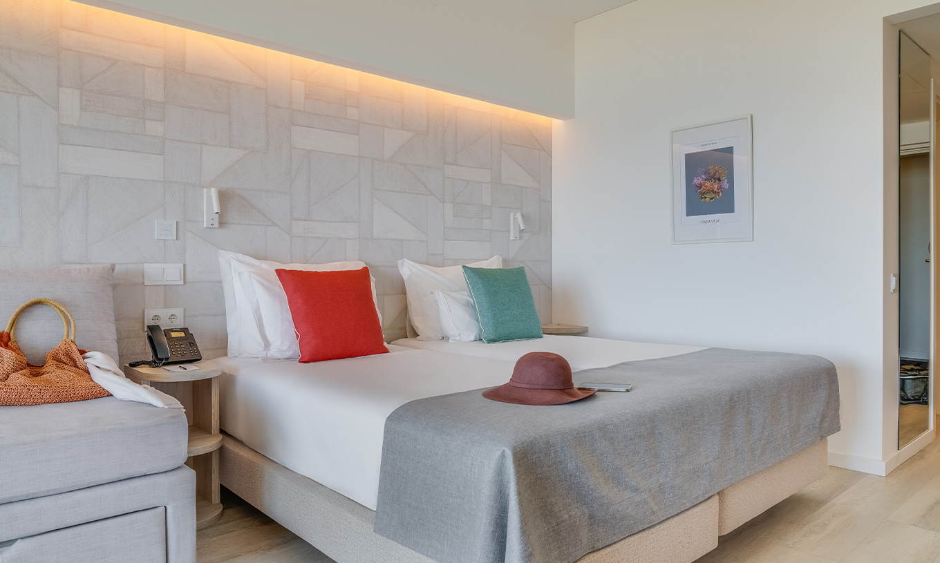 La Chambre Familiale du Pestana Blue Alvor Beach a Deux Lits Simples, un Tableau et un Grand Miroir sur le Mur