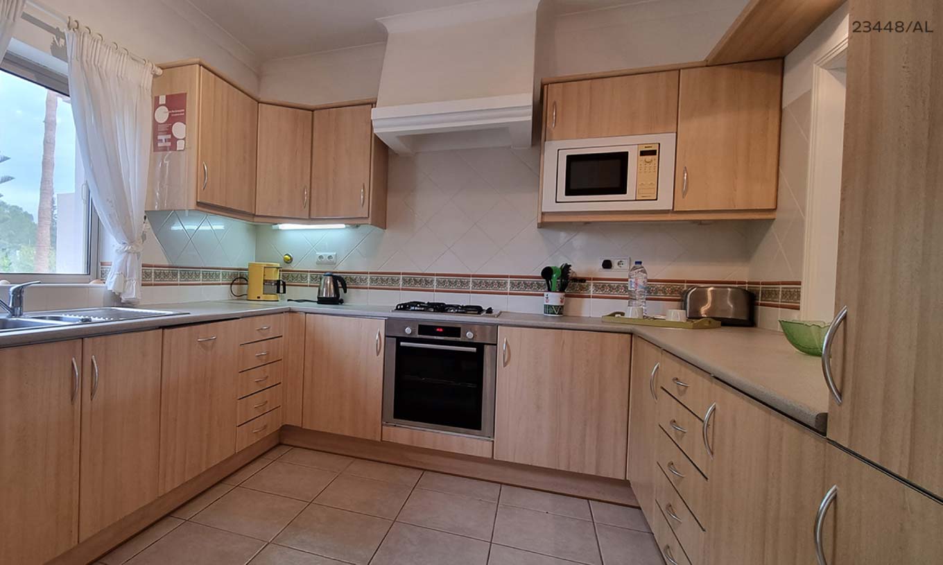 L'appartement Pestana Carvoeiro Golf T1 Standard dispose d'une cuisine avec des armoires en bois et des appareils