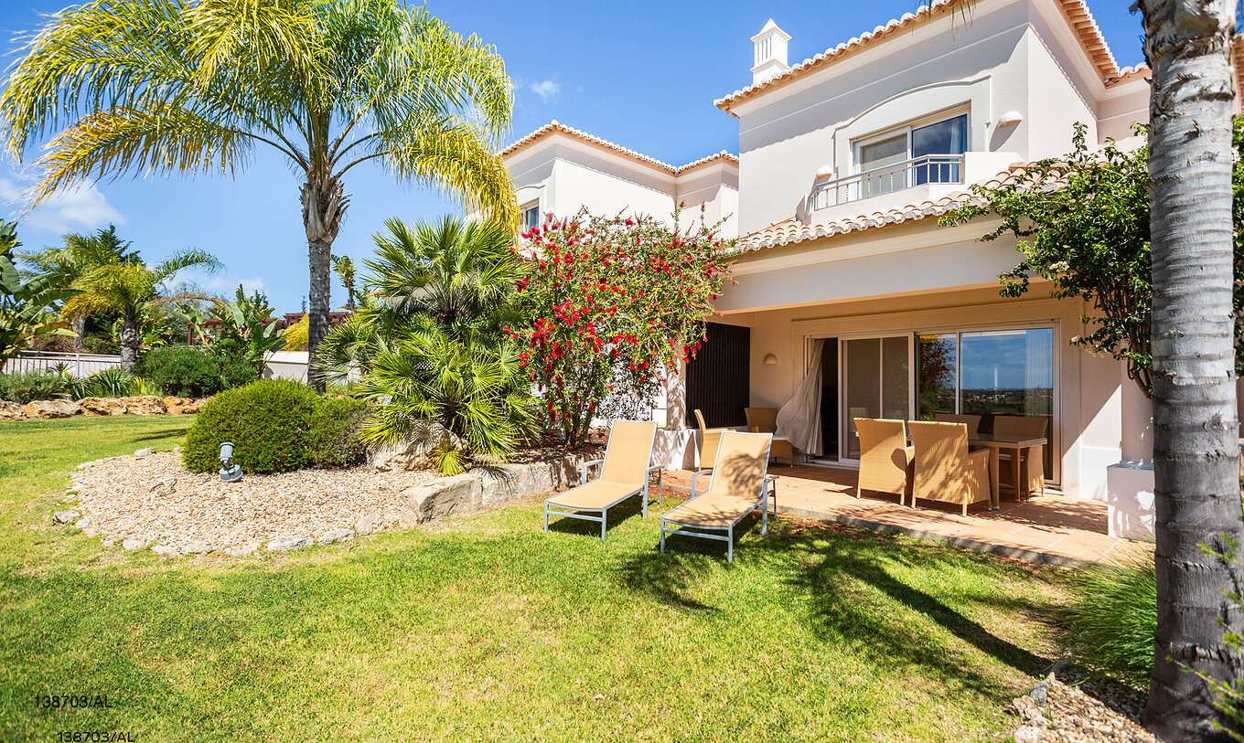 L'appartement Pestana Carvoeiro Golf T2 Superior dispose d'un espace extérieur avec une pelouse et des chaises longues jaunes