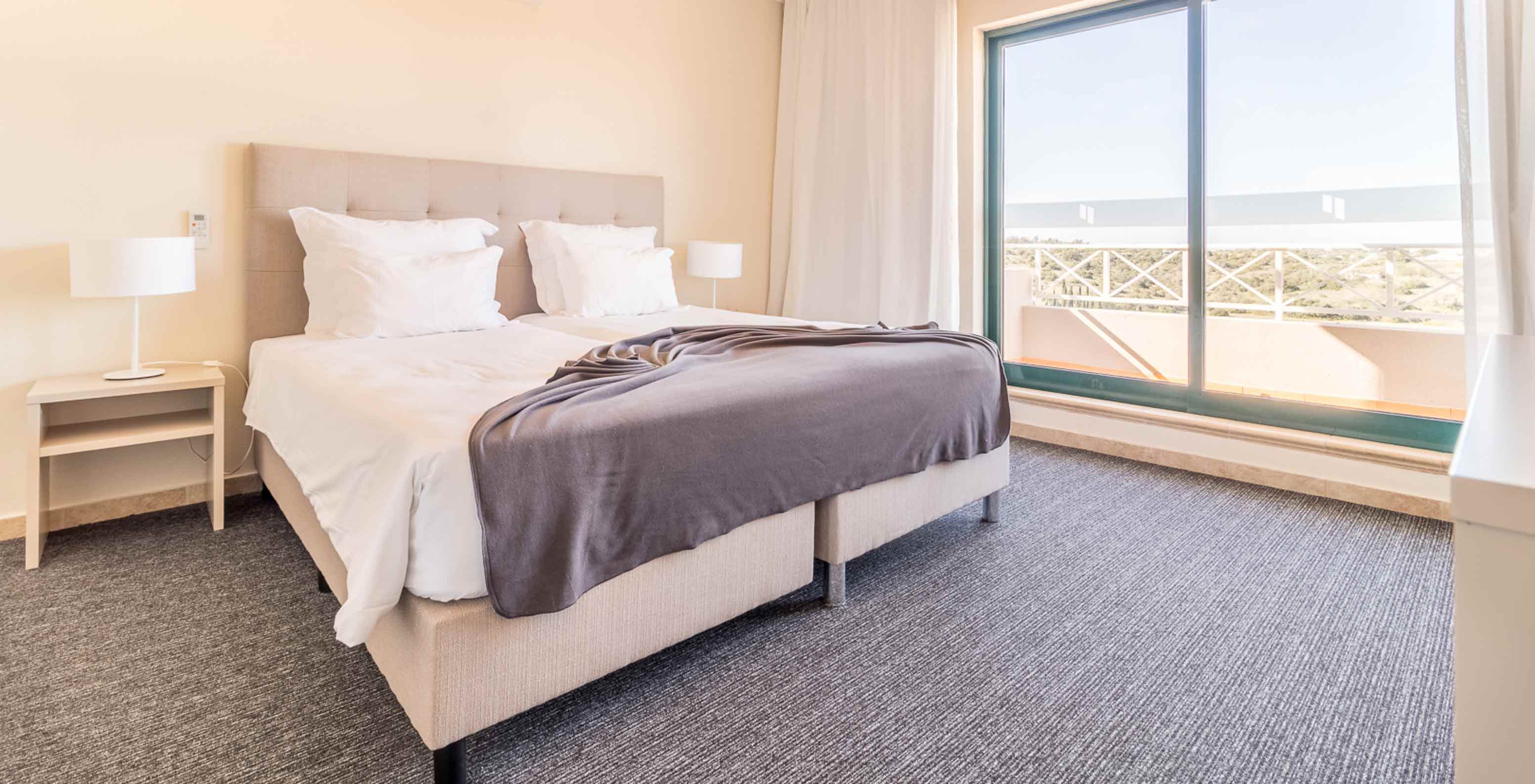 L’appartement une chambre du Pestana Gramacho a une chambre moderne avec grand lit, fenêtres et lumière naturelle