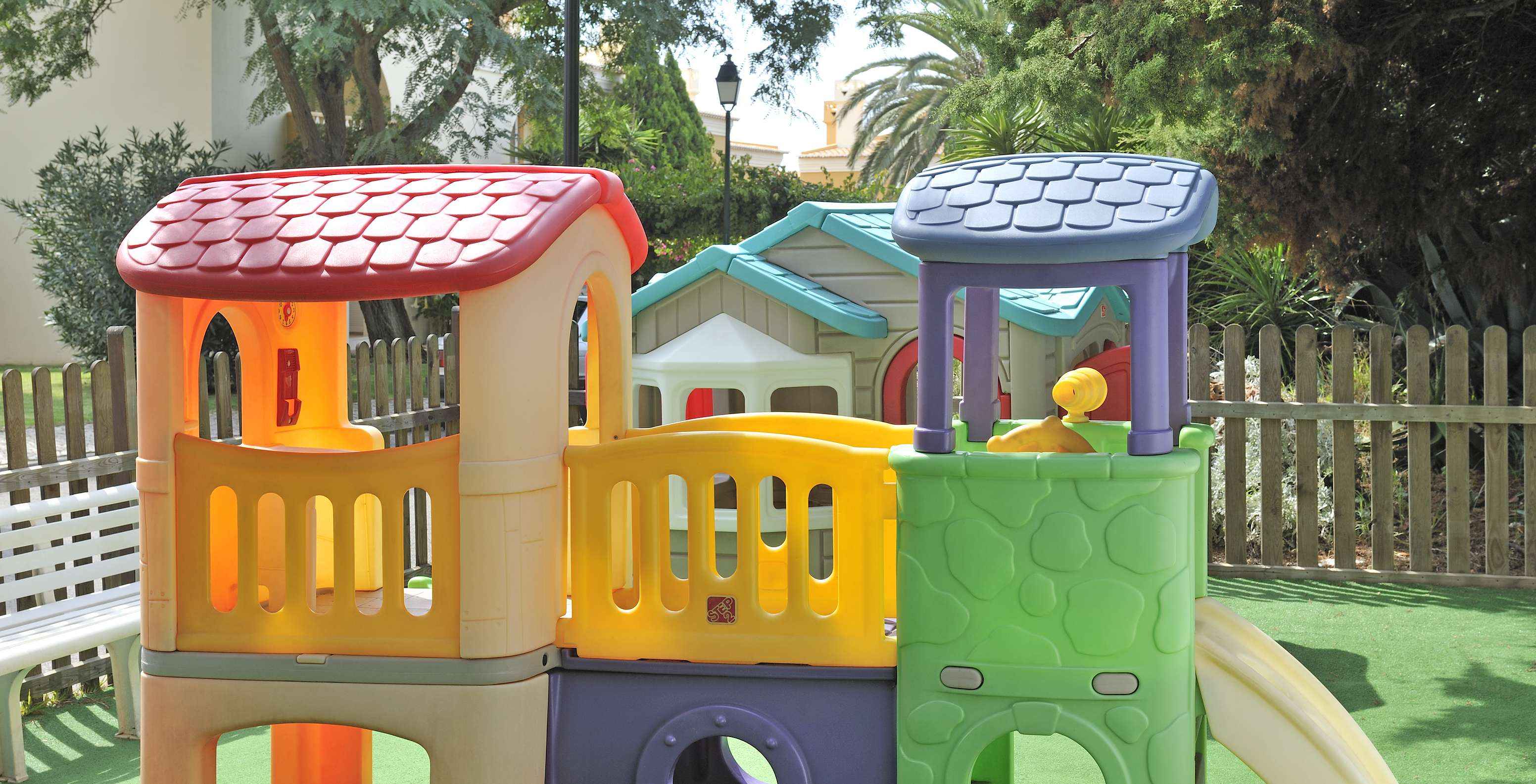 Parc pour enfants coloré avec plusieurs modules, toboggan à droite au Pestana Palm Gardens