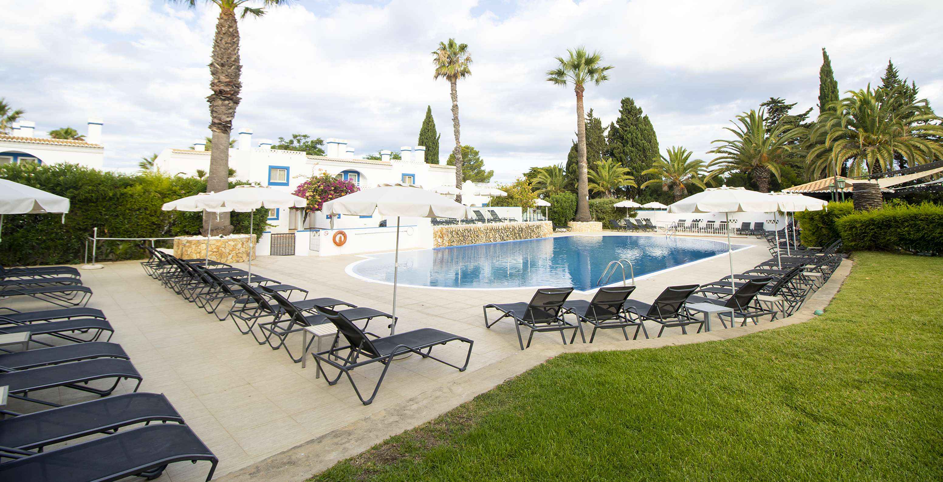 Piscine extérieure au resort au Carvoeiro, Pestana Palm Gardens, avec chaises longues, parasols et jardins