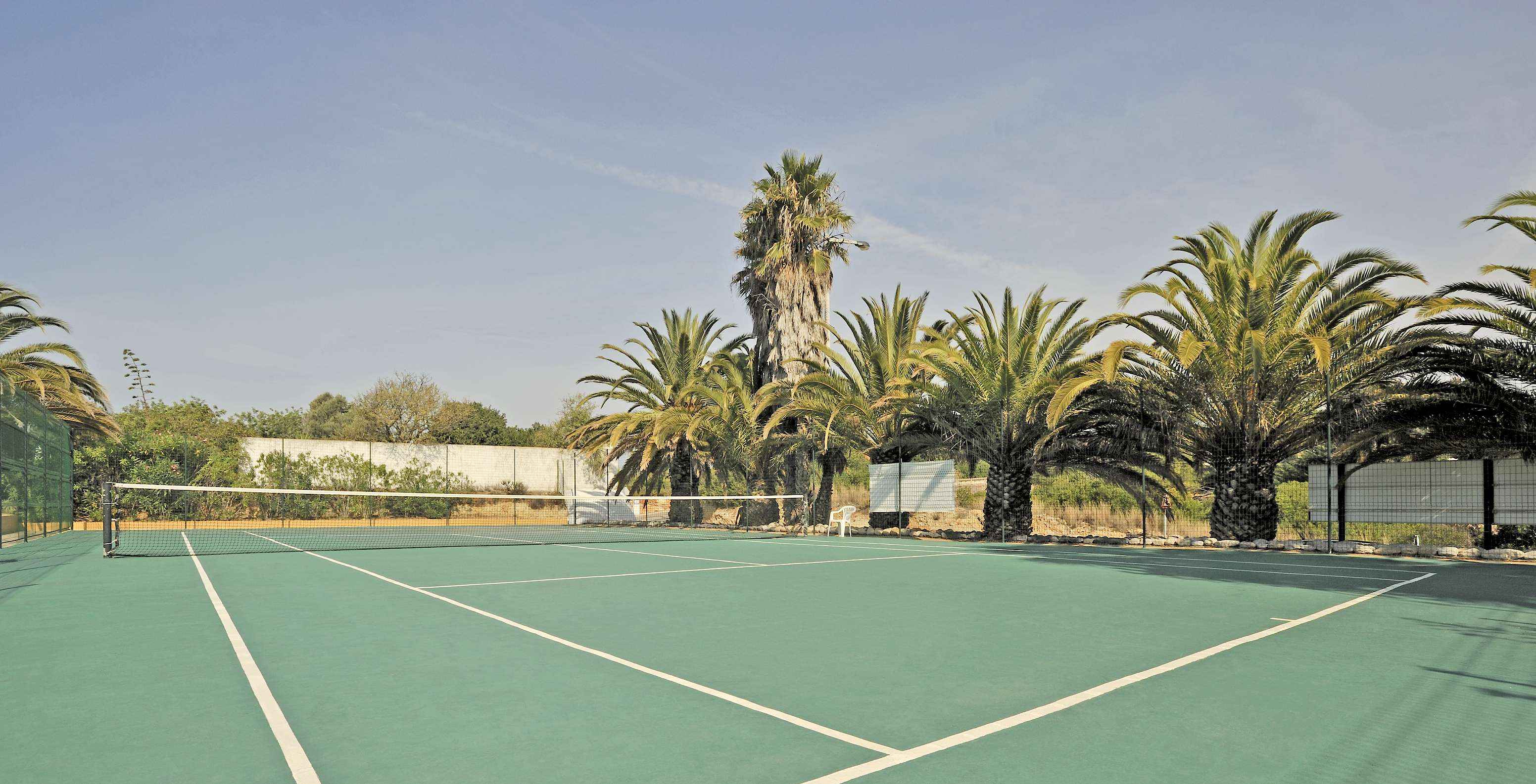 Court de tennis en dur au Pestana Palm Gardens, entouré de palmiers