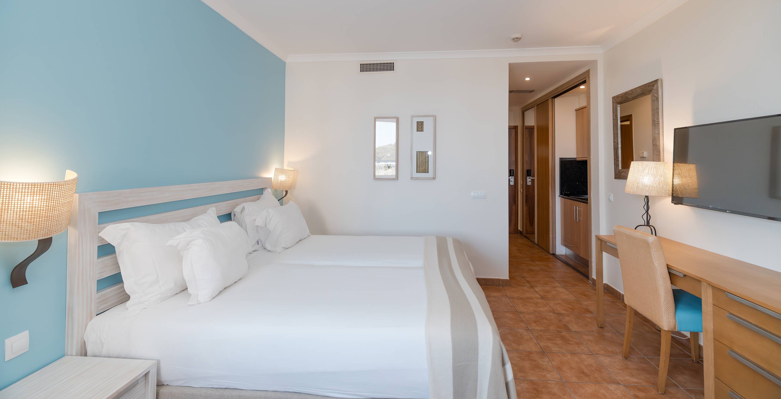 Le Deluxe Vue Jardin du Pestana Viking a deux lits, table de chevet, bureau et télévision