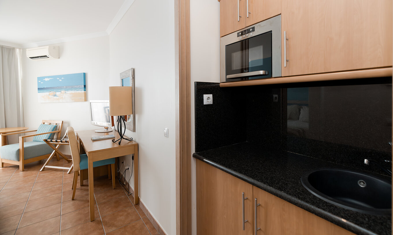Le Deluxe Vue Mer du Pestana Viking a un bureau et une petite cuisine avec micro-ondes et placards