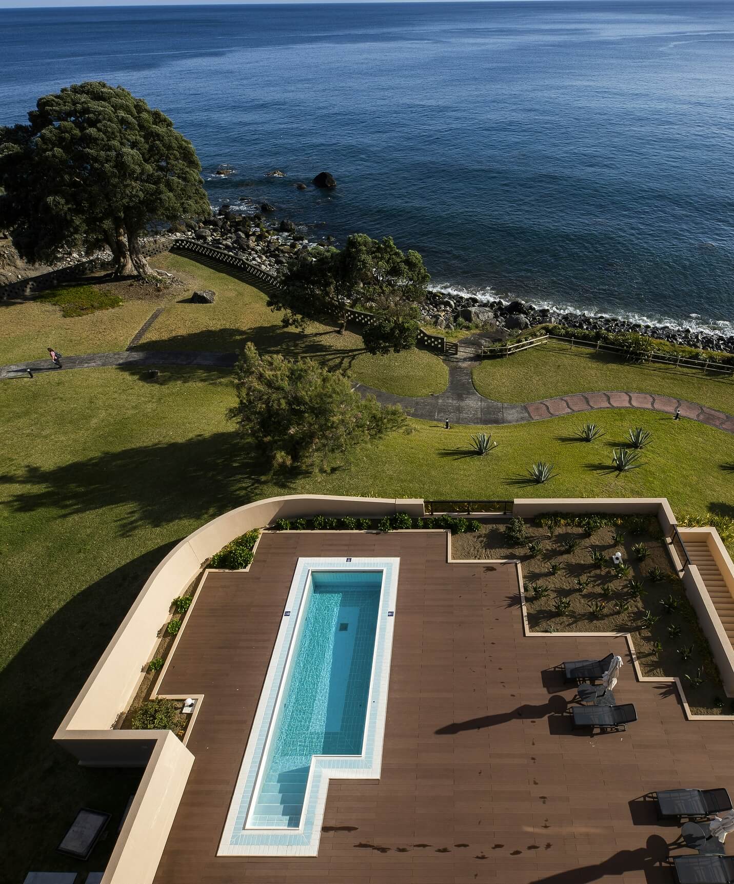 Piscine du Pestana Bahia Praia sur terrasse en bois avec vue sur la mer et zone verte autour