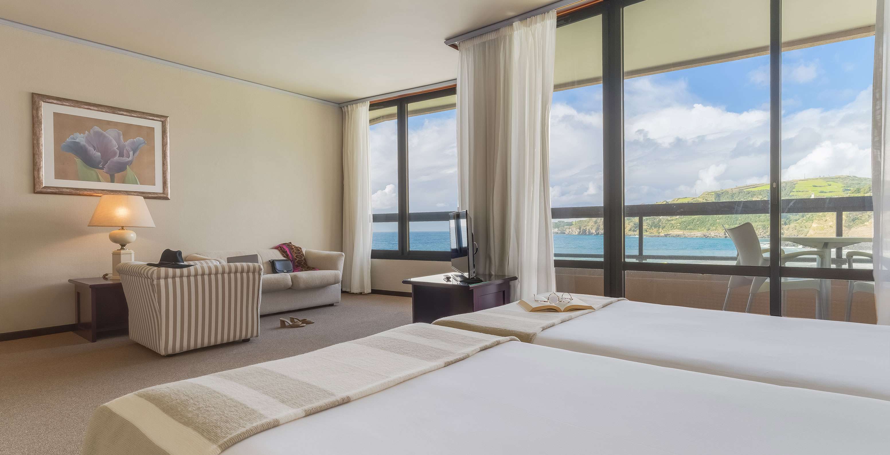 La Junior Suite Vista Mar du Pestana Bahia Praia a une belle vue sur le paysage vert et la mer avec accès à la terrasse