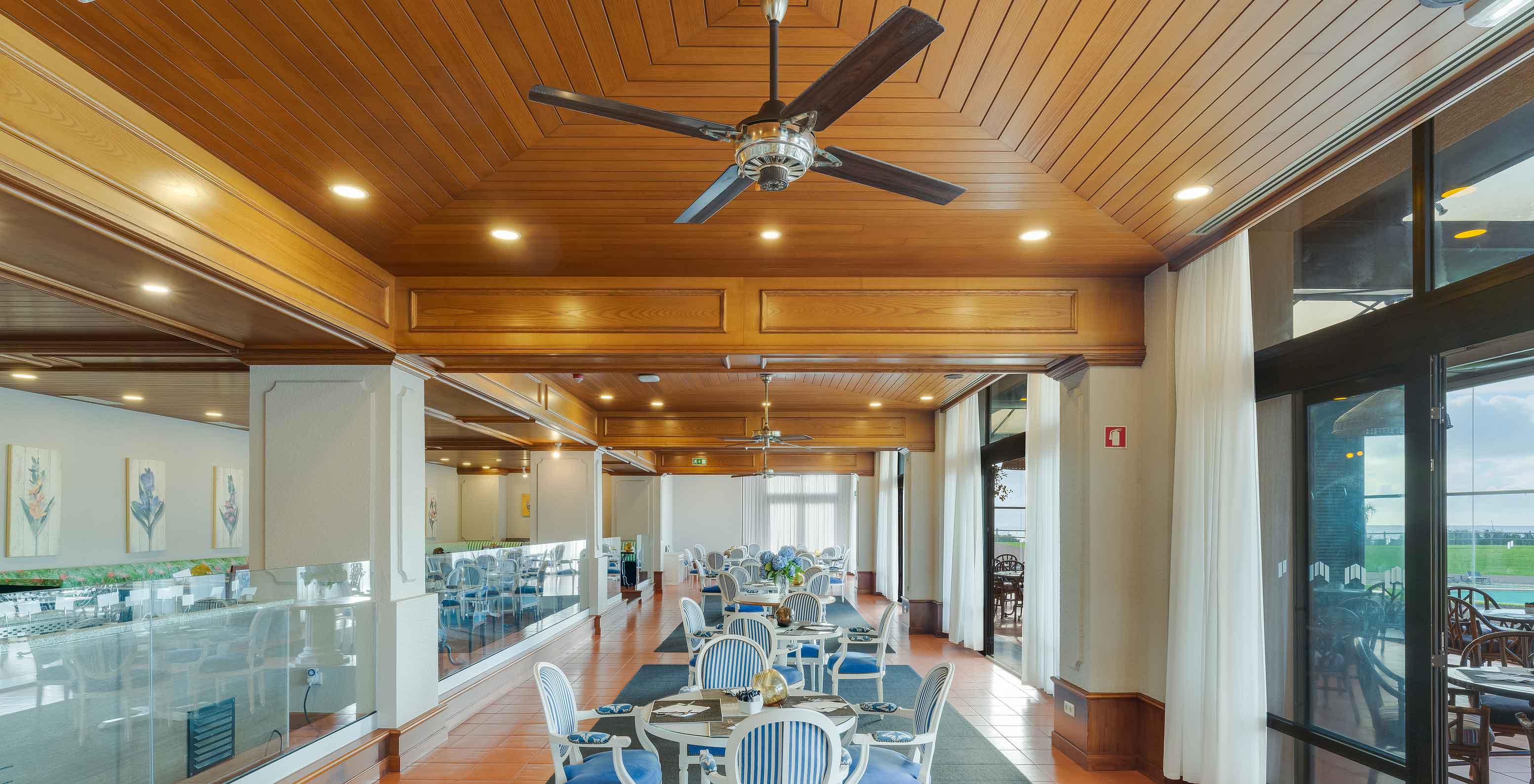 Restaurant Lugar da Praia au Pestana Bahia Praia avec tables, chaises, plafond en bois et grandes fenêtres avec vue