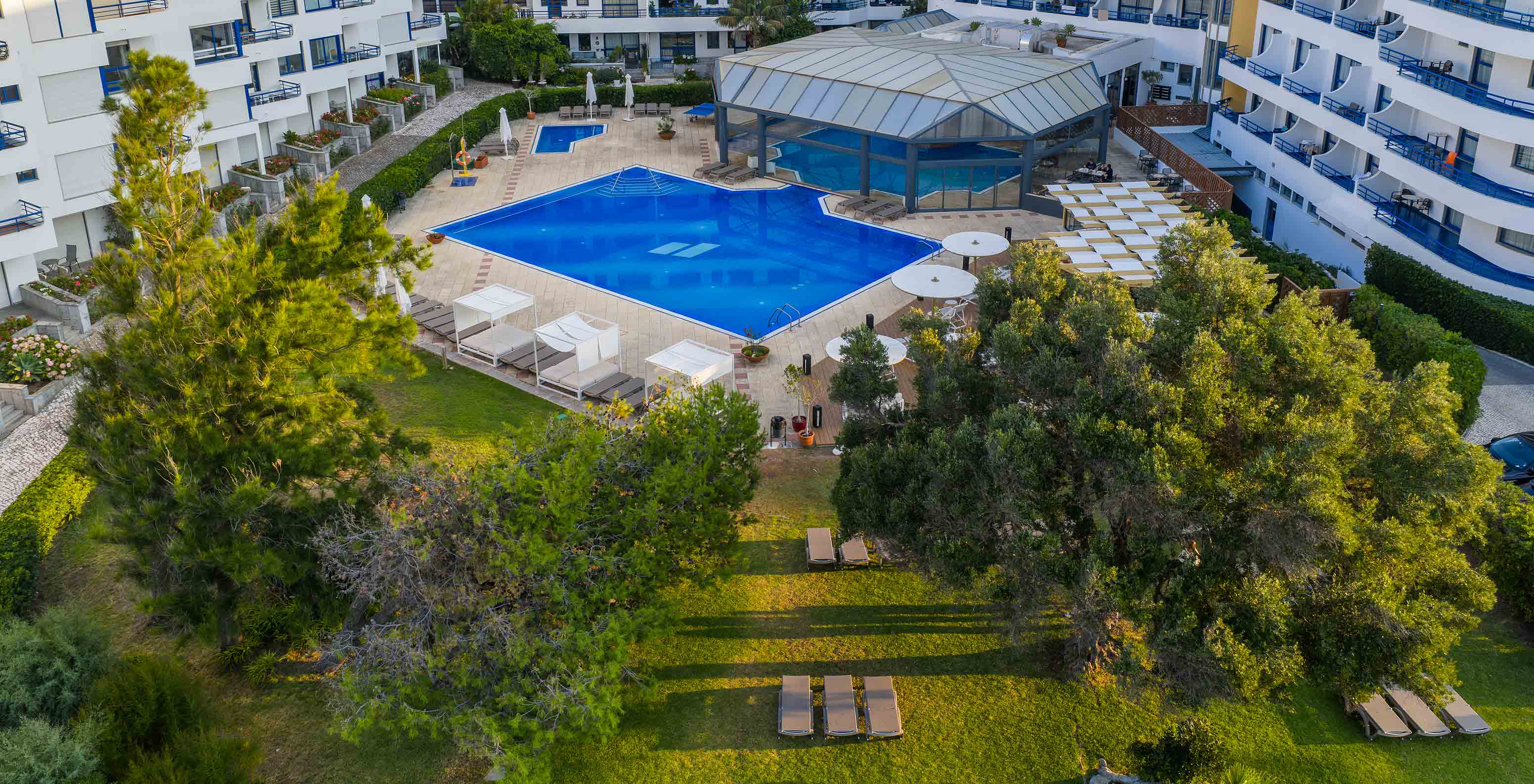 Jardin du Pestana Cascais avec piscines extérieures pour adultes et enfants, piscine intérieure et quelques transats