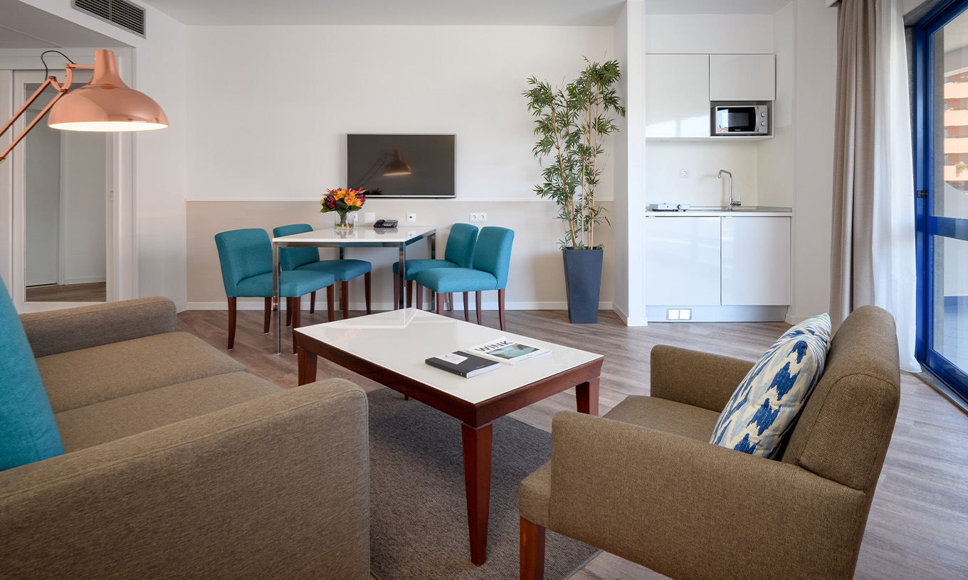 La Suite Deluxe du Pestana Cascais a un salon, avec canapé, table basse, table à manger et télévision