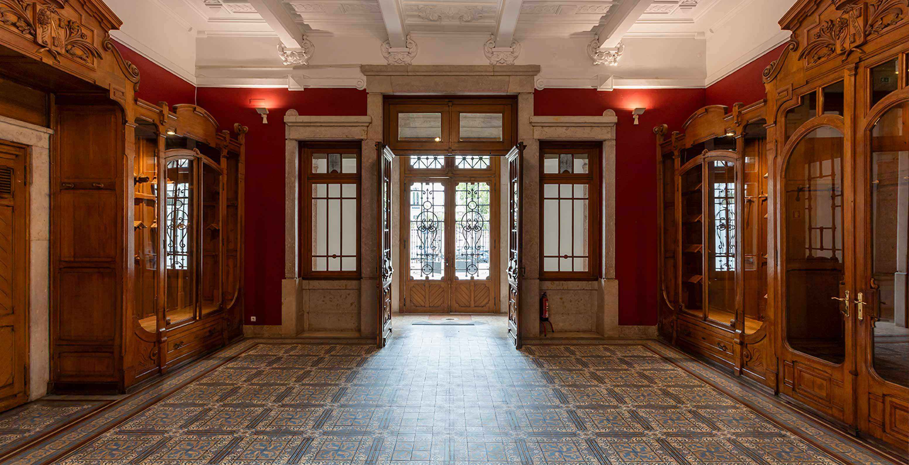 Le Pestana Palace Lisboa a une salle d'événements avec murs rouges et meubles anciens en bois	