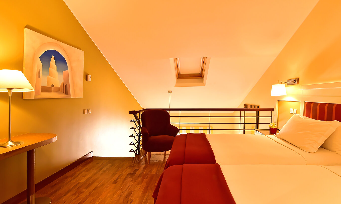 La Suite Mezzanine Familiale du Pestana Sintra Golf a une mezzanine avec deux lits, une chaise et une table