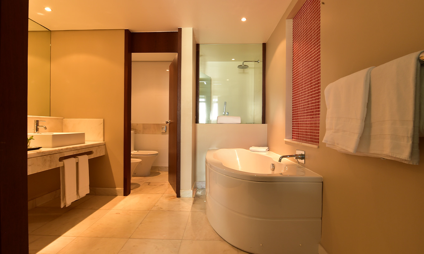 La chambre Familiale du Pestana Casino Park a une salle de bains avec baignoire et douche, toilettes et lavabo