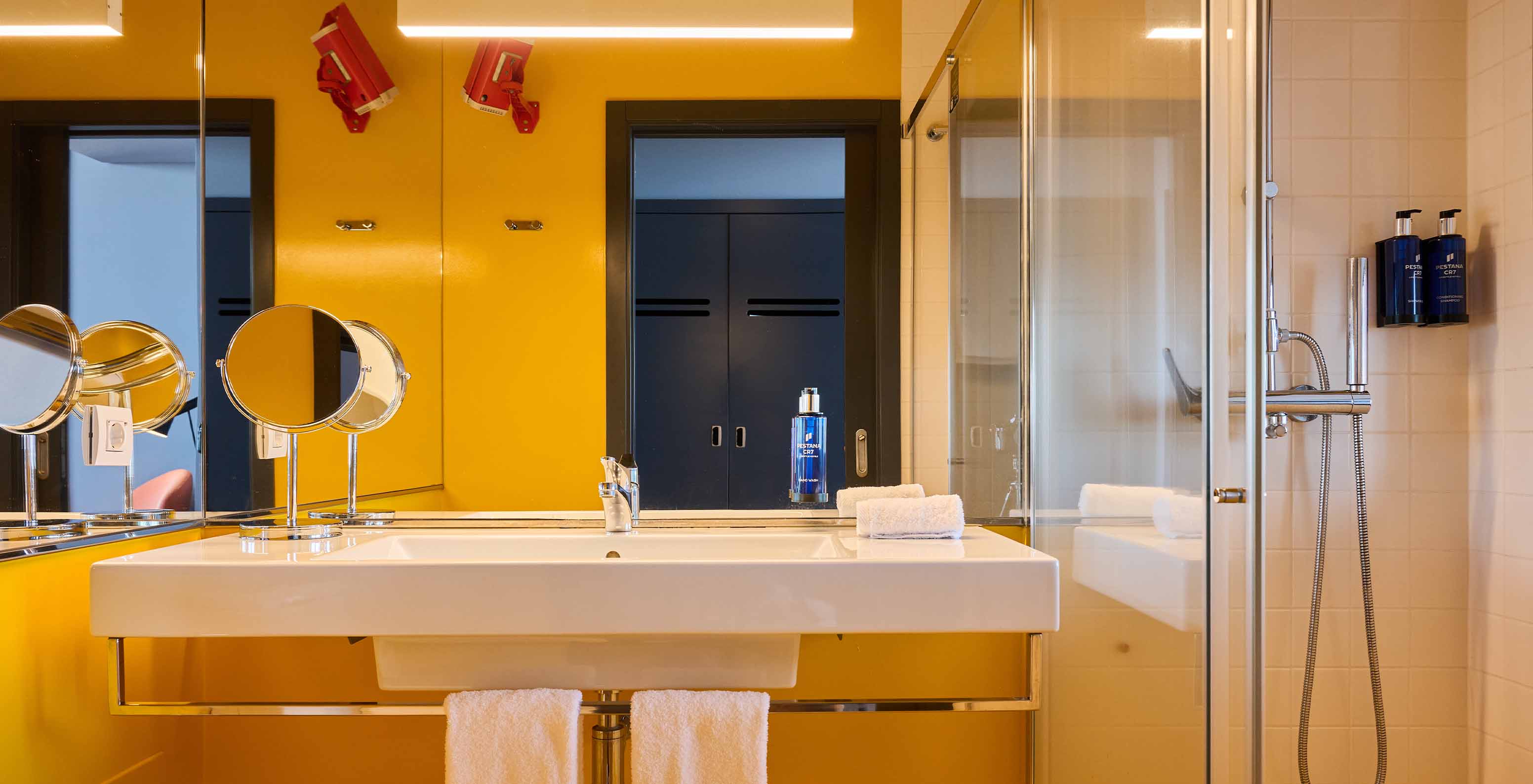 La Chambre CR Superior du Pestana CR7 Funchal a une salle de bain moderne, jaune, avec douche élégante