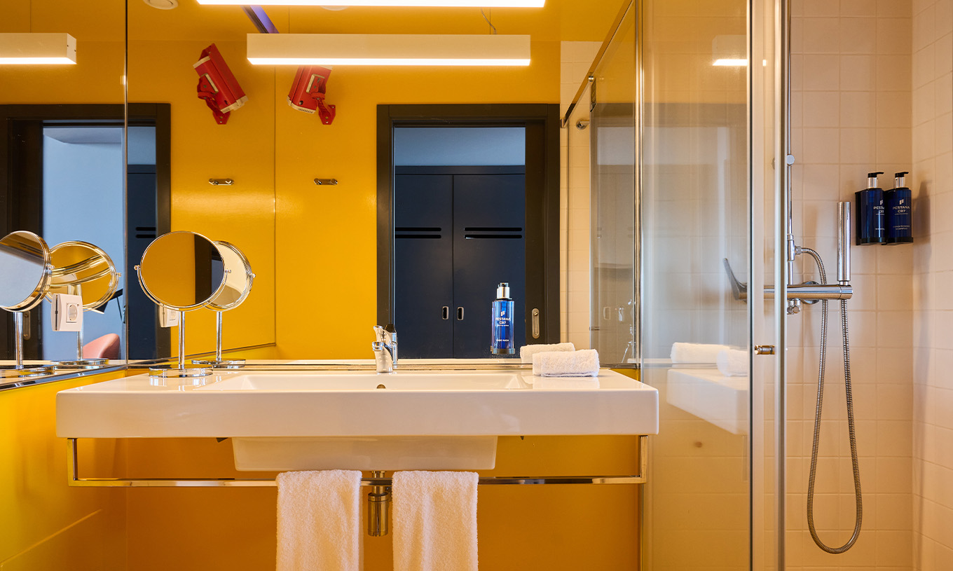La Chambre CR Superior du Pestana CR7 Funchal a une salle de bain moderne, jaune, avec douche élégante