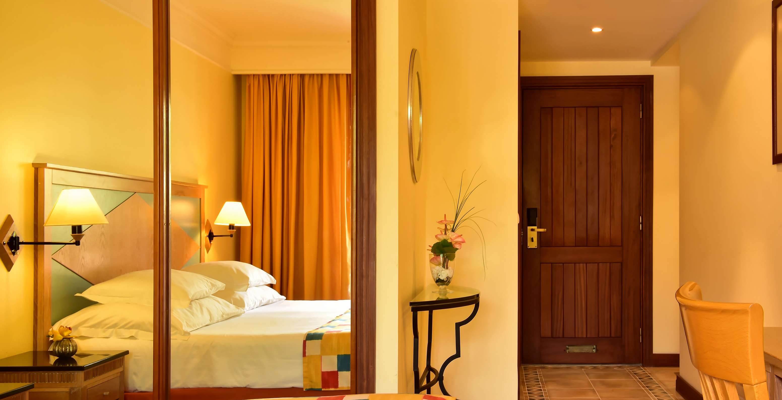 Le Supérieur du Pestana Miramar a un lit double avec une couverture à carreaux et un placard avec miroir