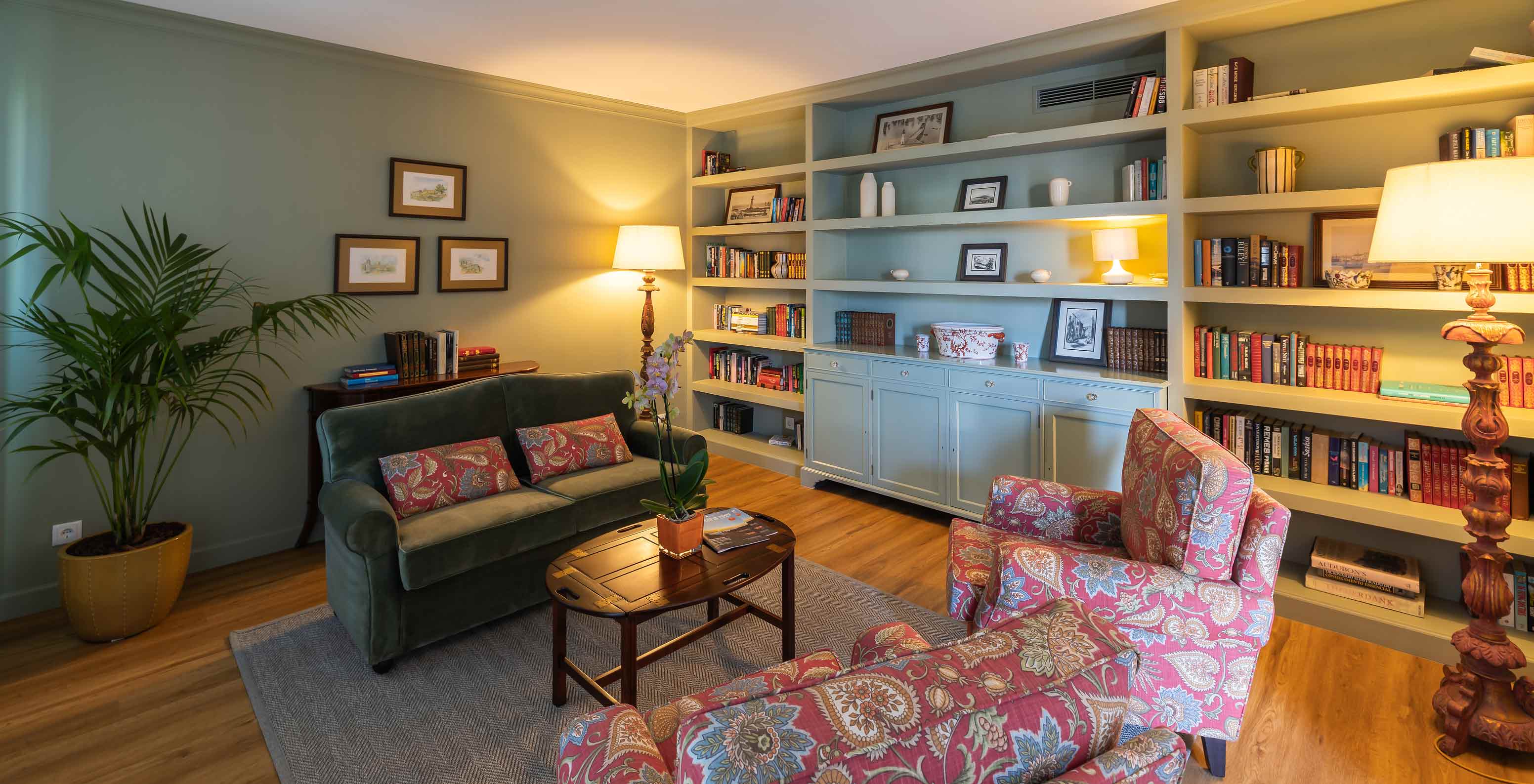 Bibliothèque du Pestana Quinta Perestrello avec un canapé, une étagère, une plante et un lampadaire