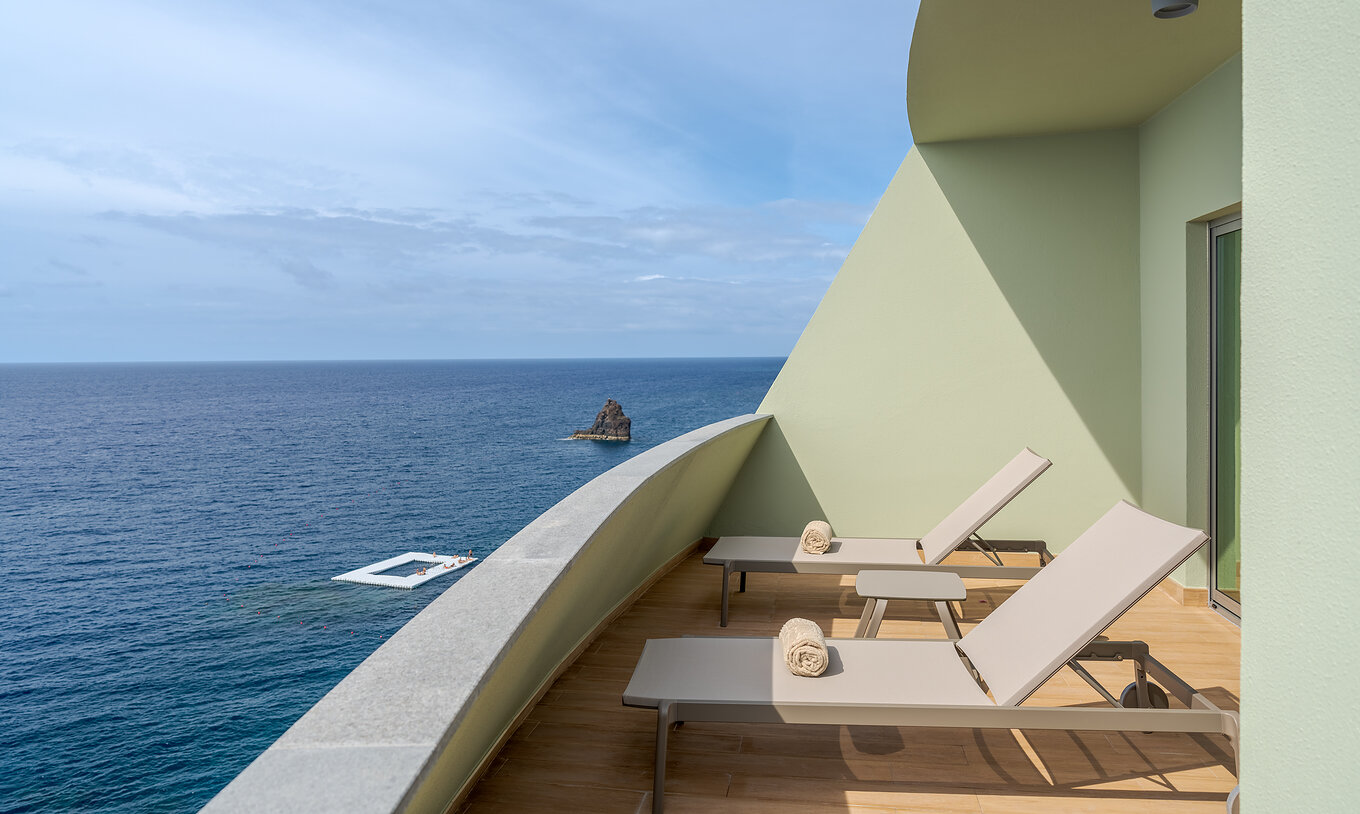 La Suite Supérieure Vue Mer du Pestana Vila Lido Madeira a un balcon avec deux chaises longues et vue sur la mer