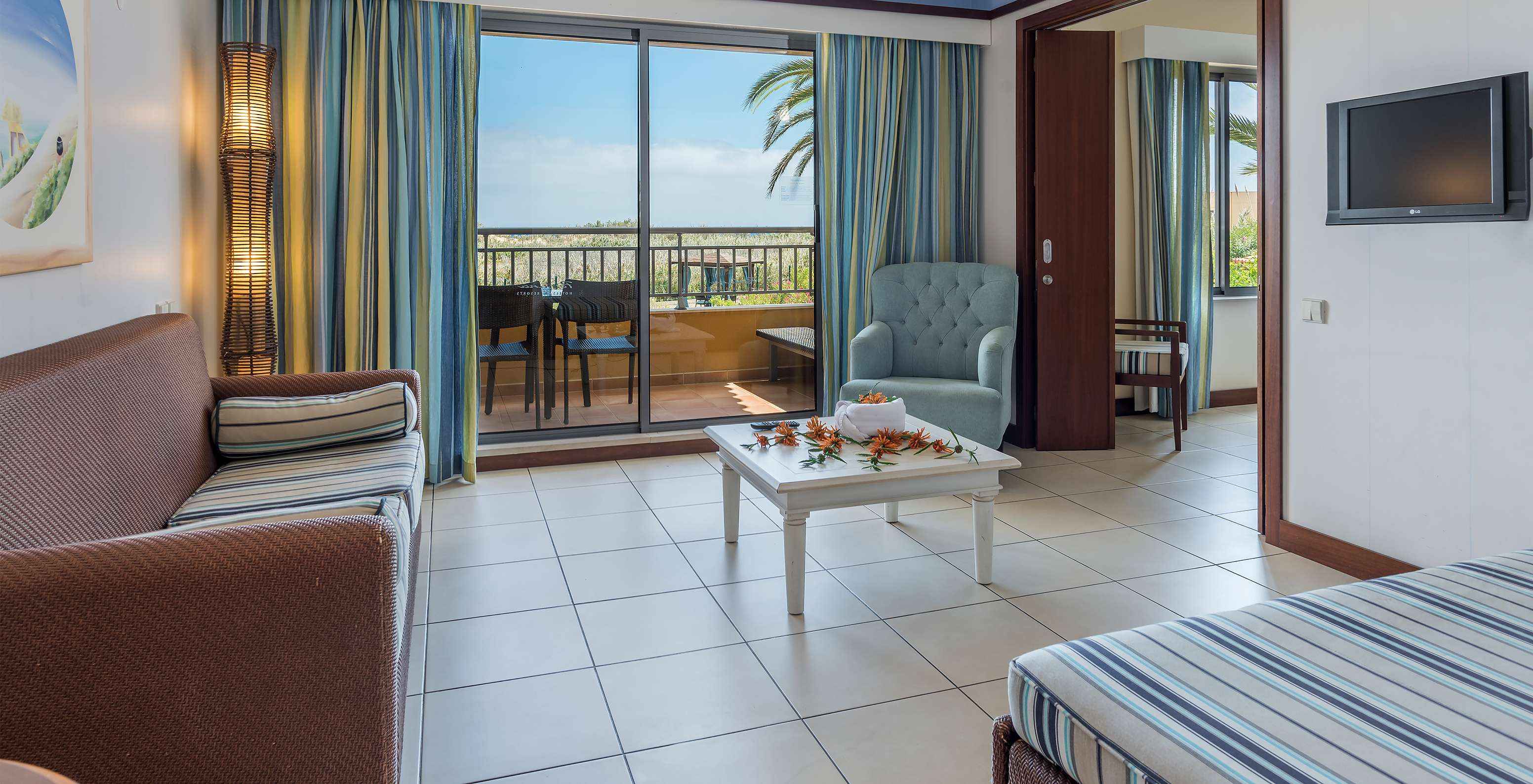 La Suite Appartement T1 du Pestana Porto Santo All Inclusive a un salon avec accès au balcon, vue jardin