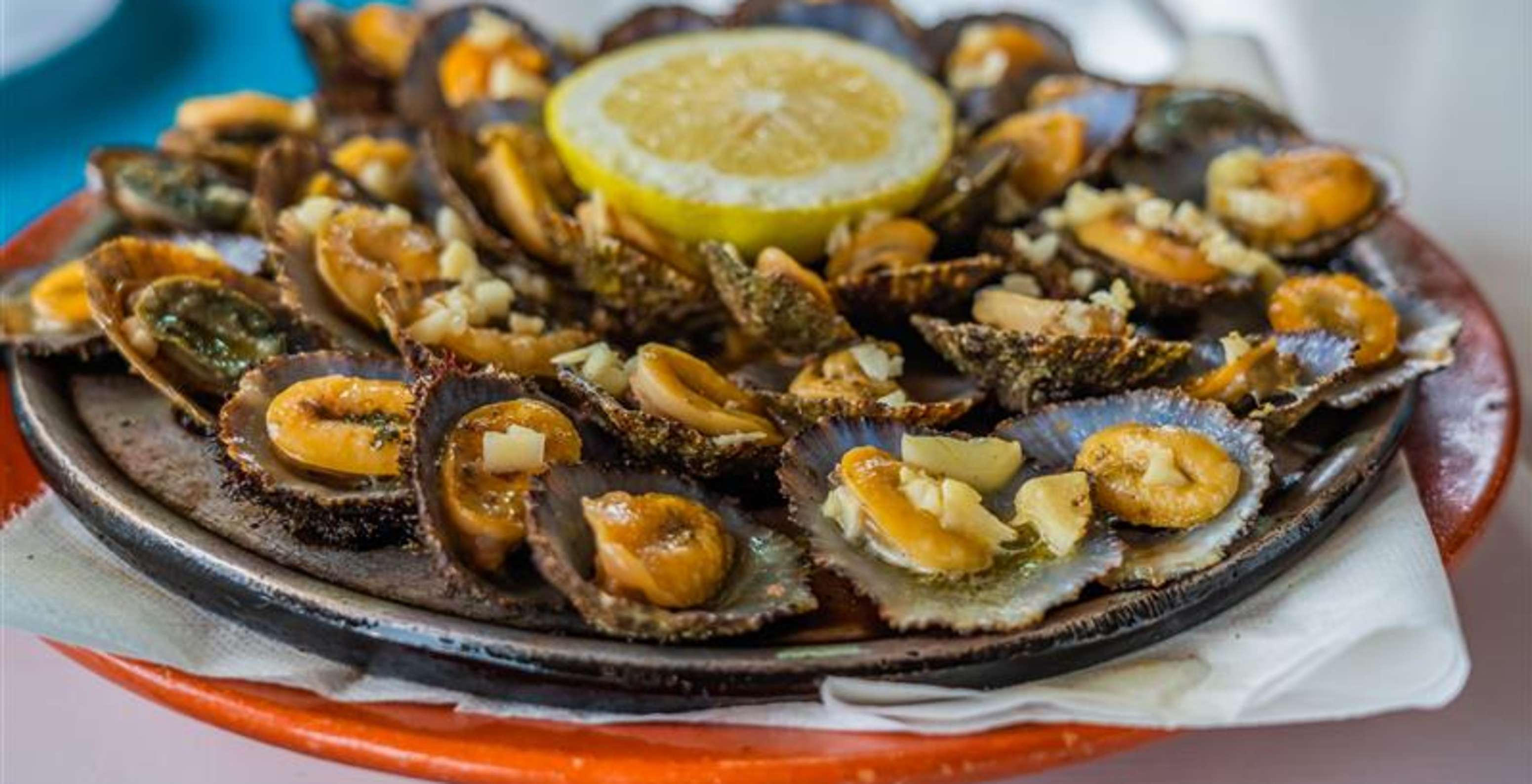 Restaurant Madeira Lovers, Resort 5 étoiles à Porto Santo a un plat de patelles avec citron au milieu