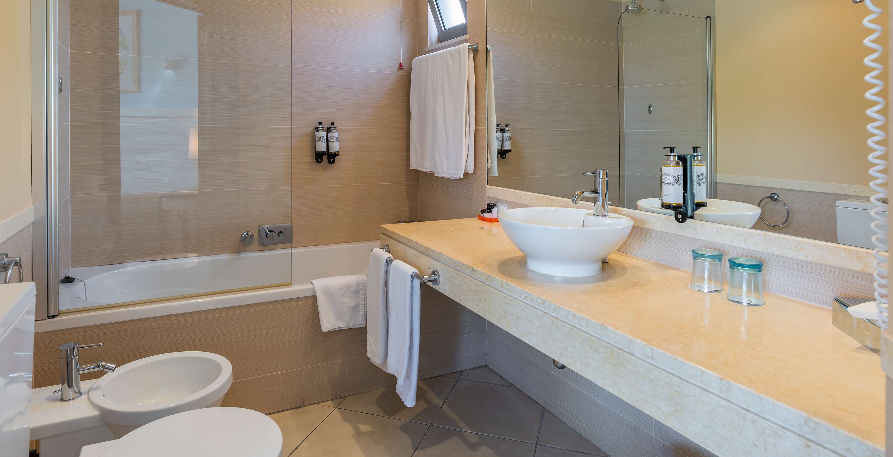 La Suite Appartement T1 du Pestana Porto Santo All Inclusive a une salle de bain avec bidet, lavabo, miroir et baignoire