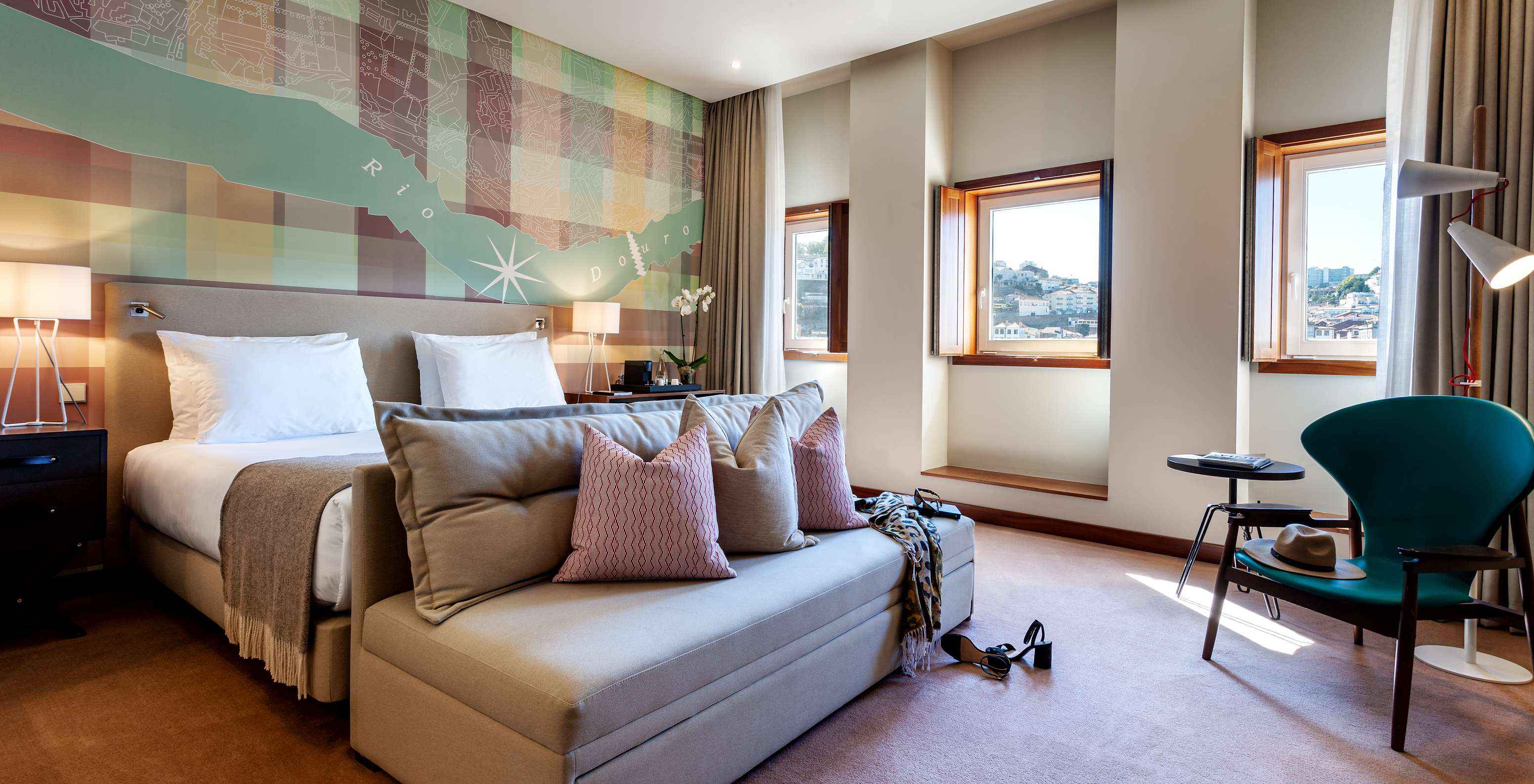 Le Vintage Front View du Pestana Vintage Porto a un lit double avec un canapé aux pieds, trois fenêtres et un fauteuil