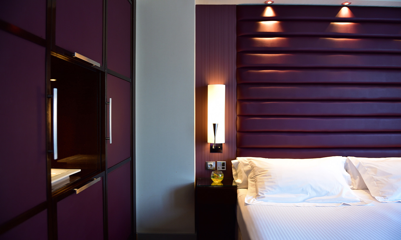 La chambre Standard du Pestana Arena Barcelona a une décoration moderne en violet, un lit double et un placard