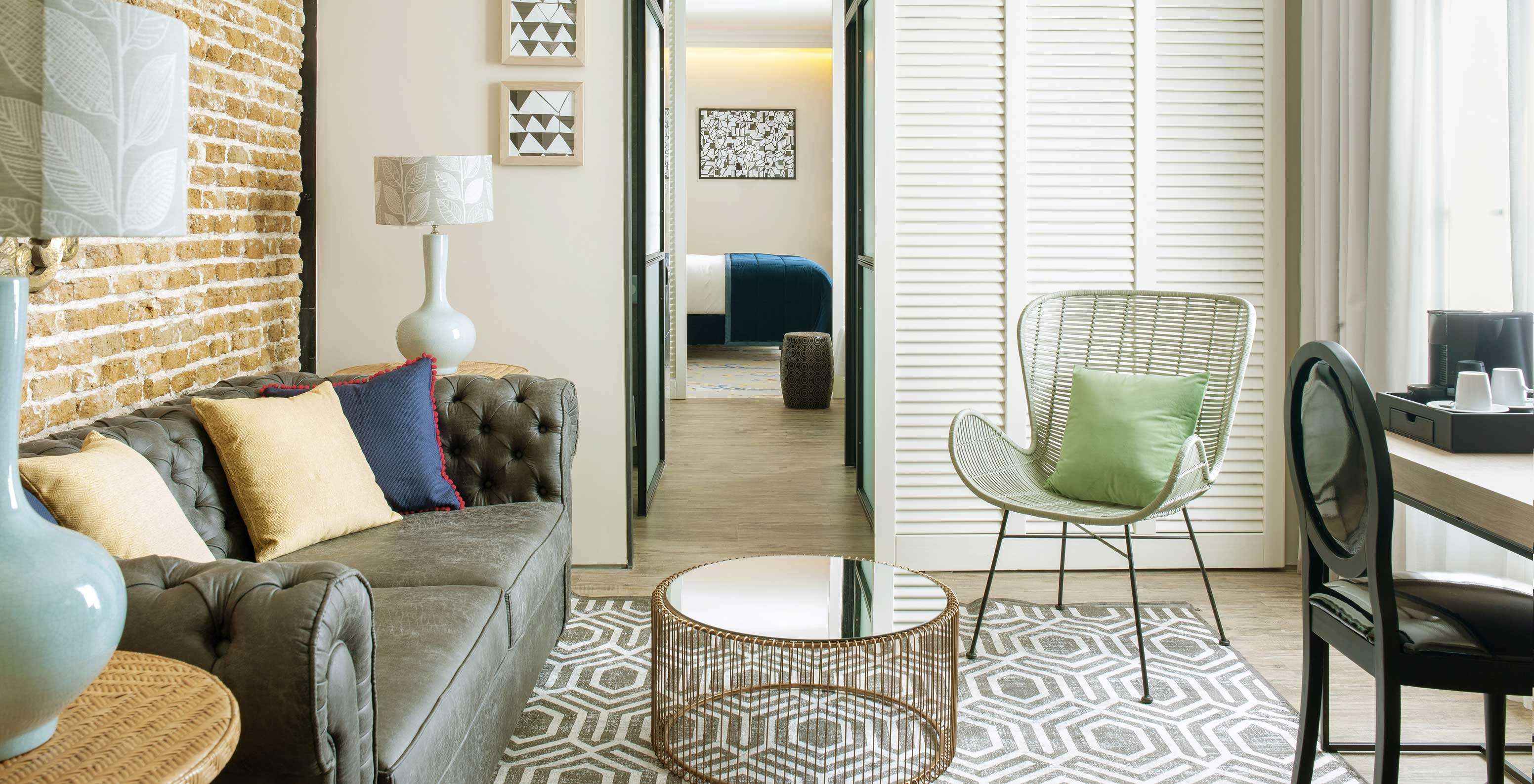 La Suite du Pestana Plaza Mayor dispose d’un salon séparé avec canapé, tables d’appoint, lampes et machine à café