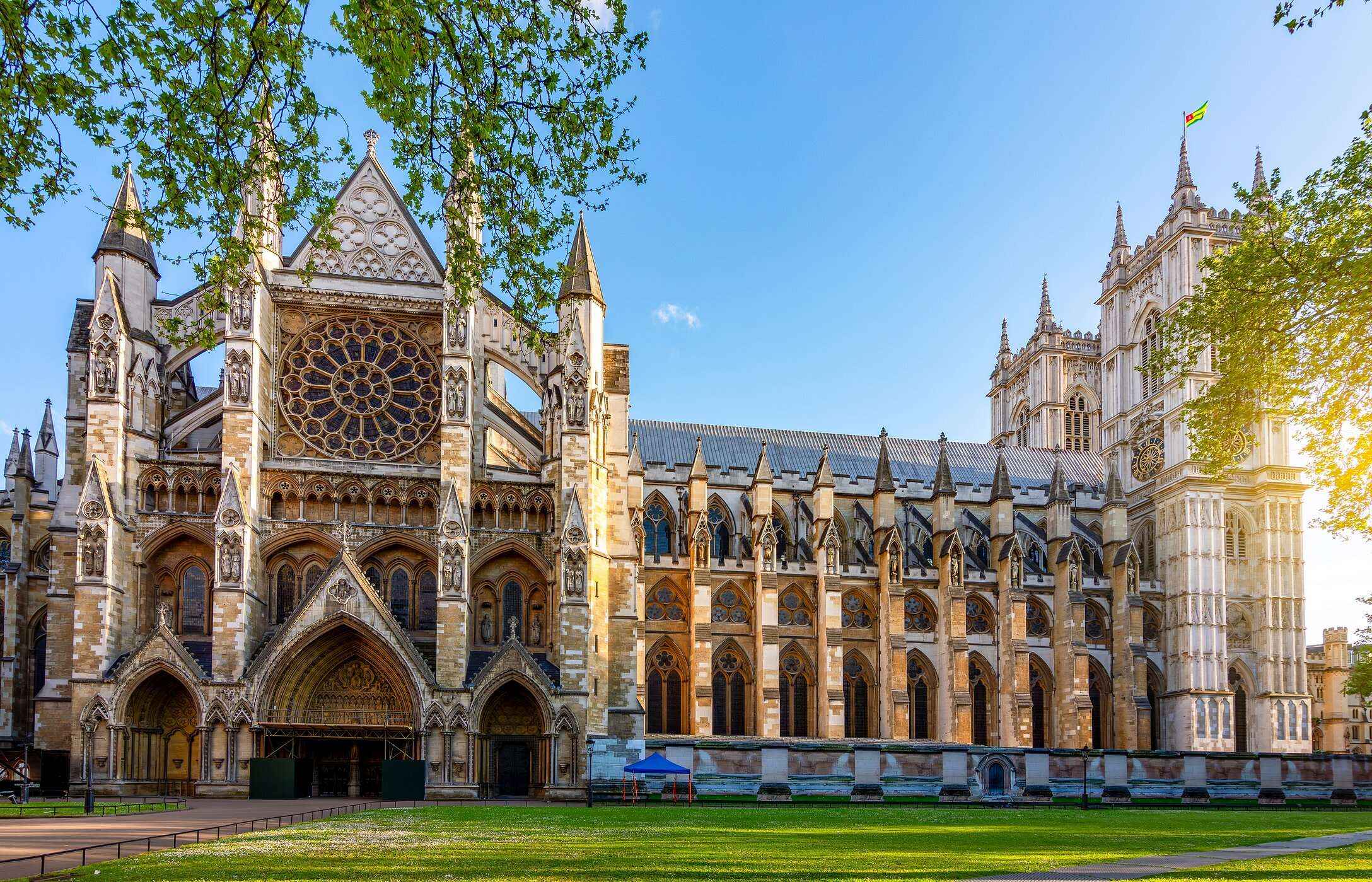 Façade de l'abbaye de Westminster à Londres, avec ses arcs gothiques, son vitrail circulaire et ses tours pointues.
