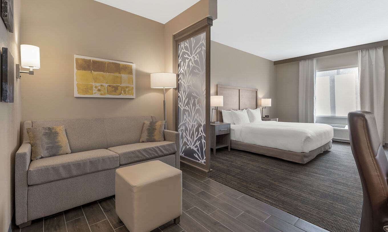 La Suite King du Pestana Orlando Suites Lake Buena Vista a un lit double, table de chevet, canapé et lampe