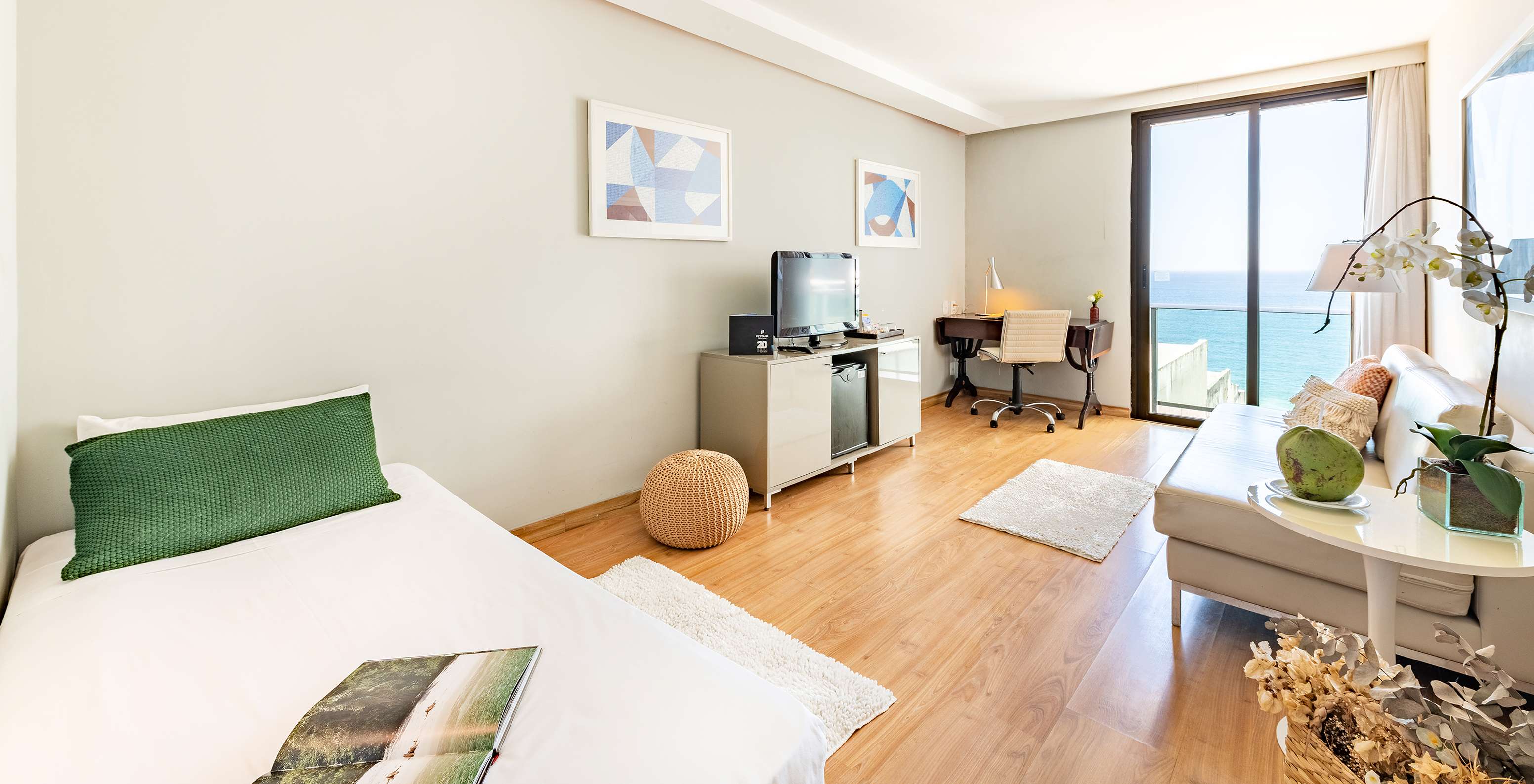 De Suite Zijdelings uitzicht op zee van Pestana Rio Atlântica heeft een woonkamer met bank, televisie en raam met uitzicht op de zee