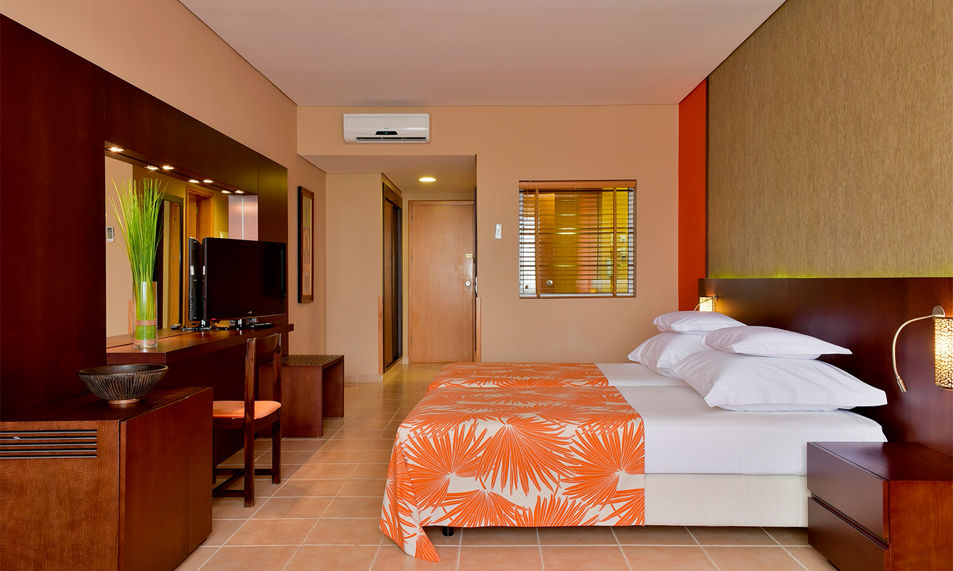 De standaardkamer van Pestana Tropico heeft twee eenpersoonsbedden, televisie, nachtkastje, spiegel en een stoel