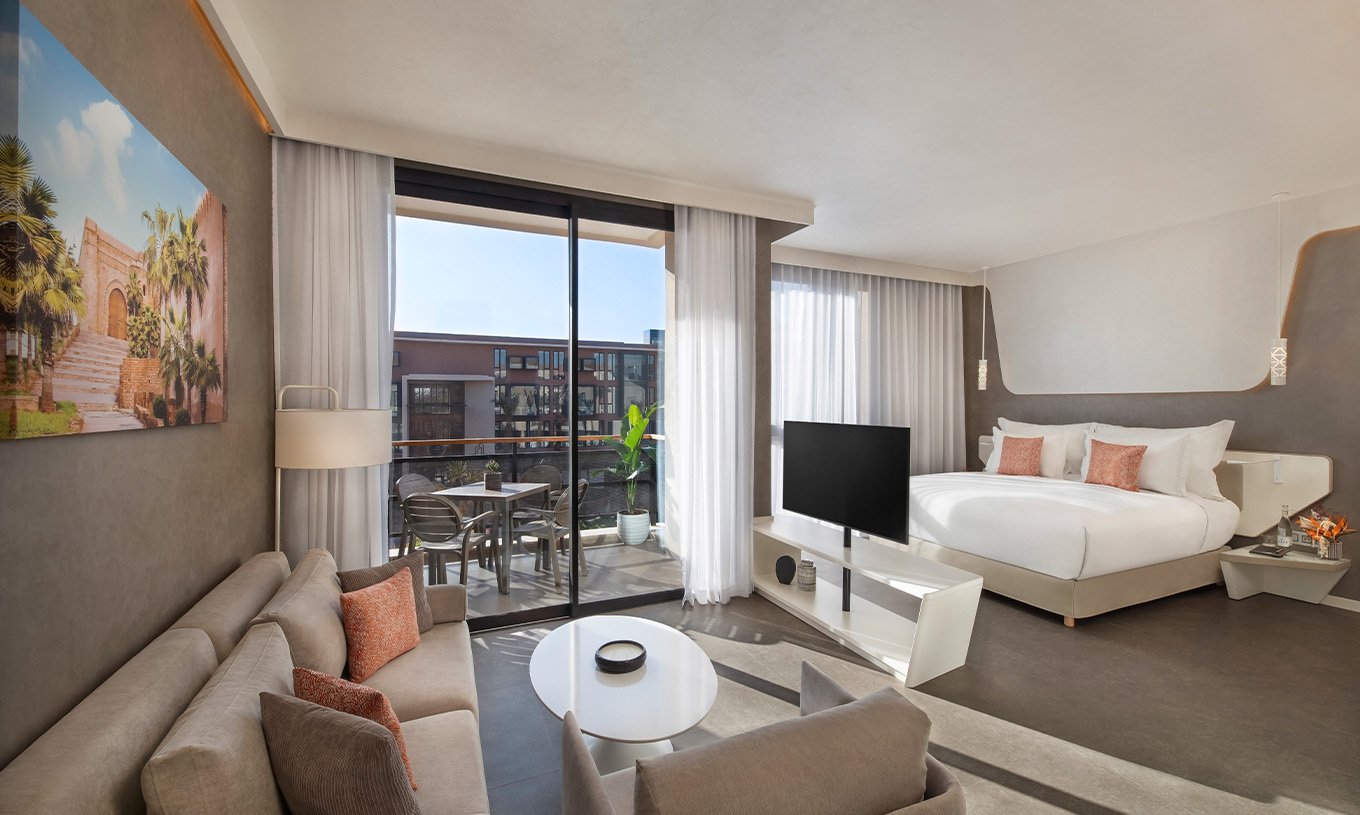 De CR7 Junior Suite Avenue van Pestana CR7 Marrakech heeft een zithoek met banken en televisie, en een balkon met een tafel