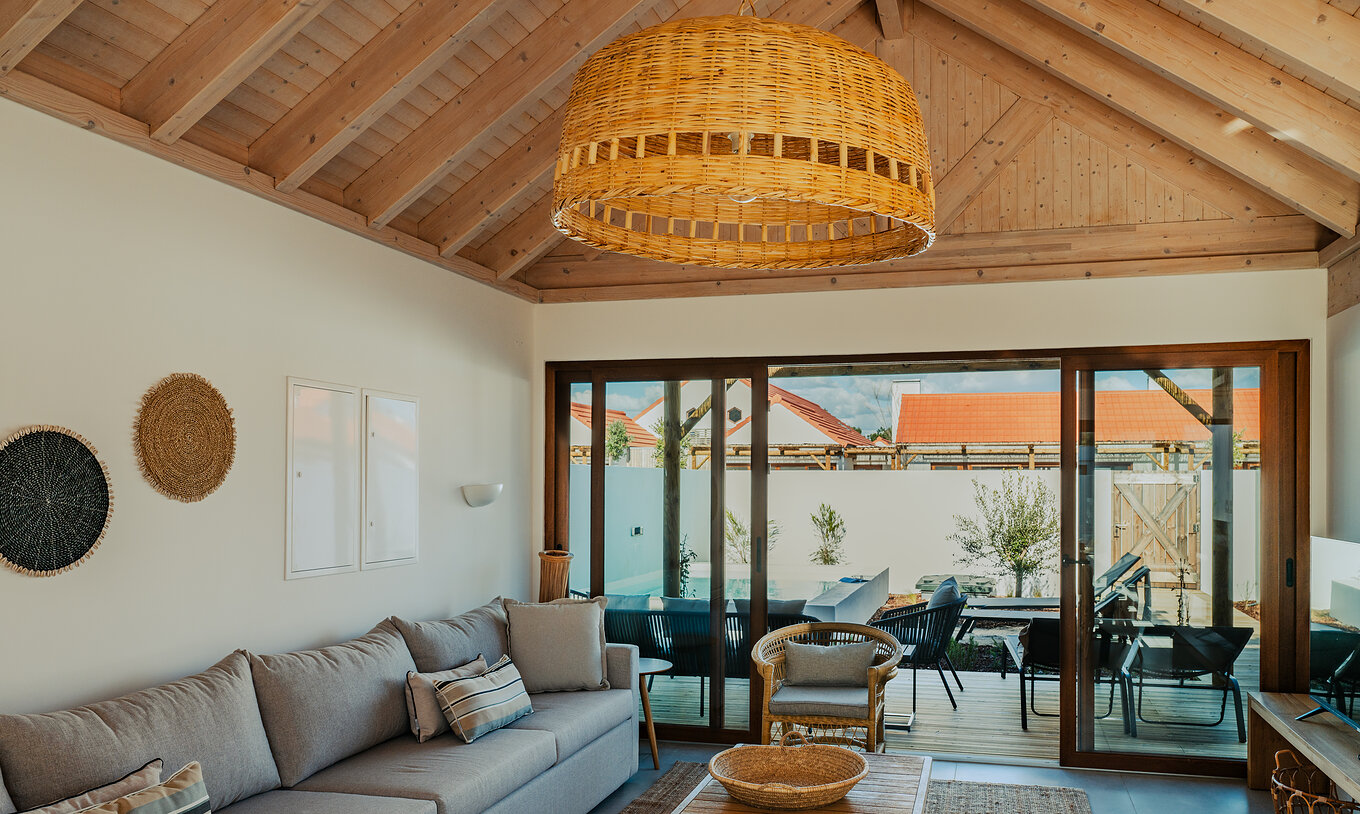 De Superieure Villa bij Pestana Comporta Village Residences heeft een woonkamer met een grijze bank en een balkon achteraan
