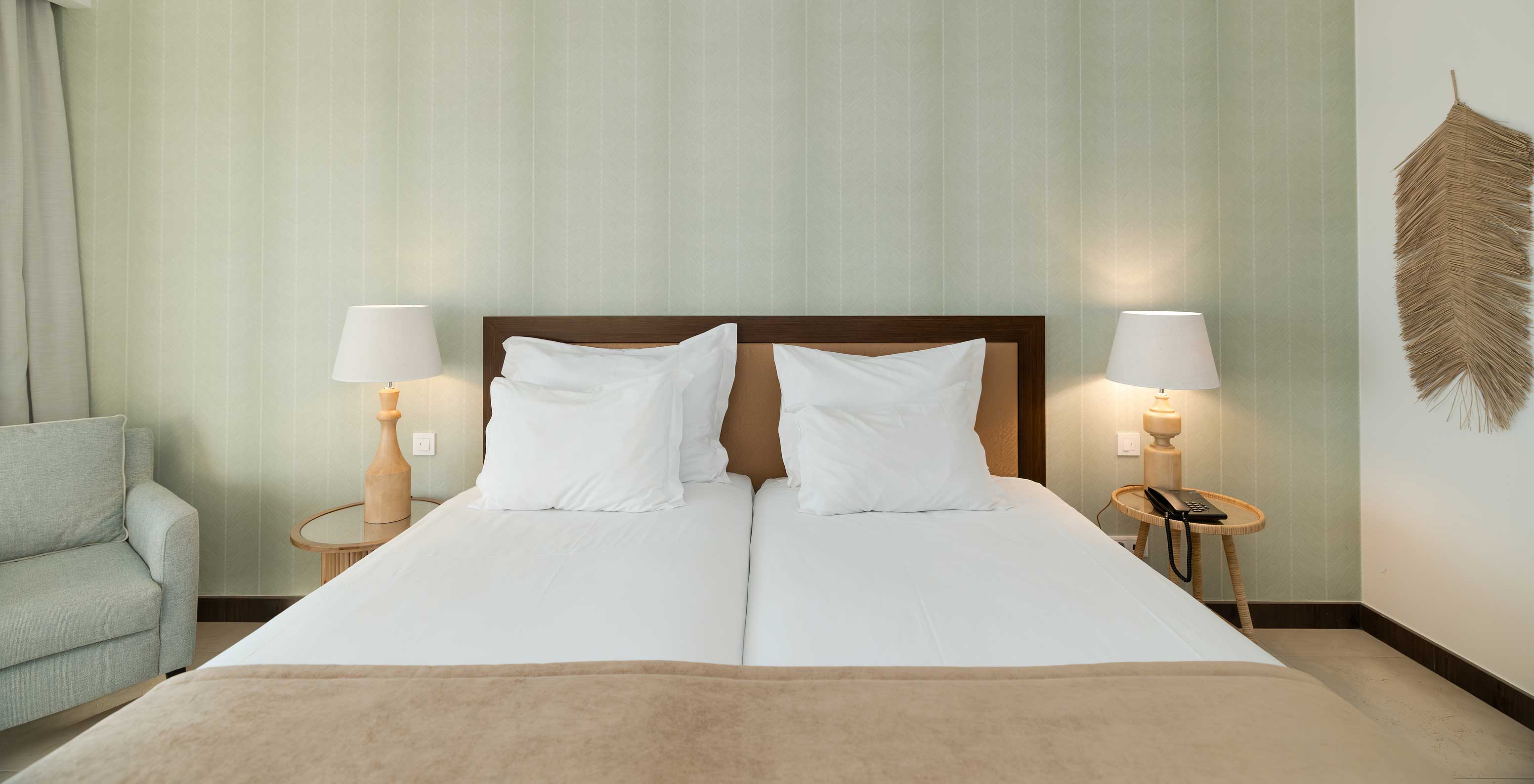 Studio Tuinzicht bij Pestana Alvor Beach Villas heeft twee bedden met nachtkastje en groen behang