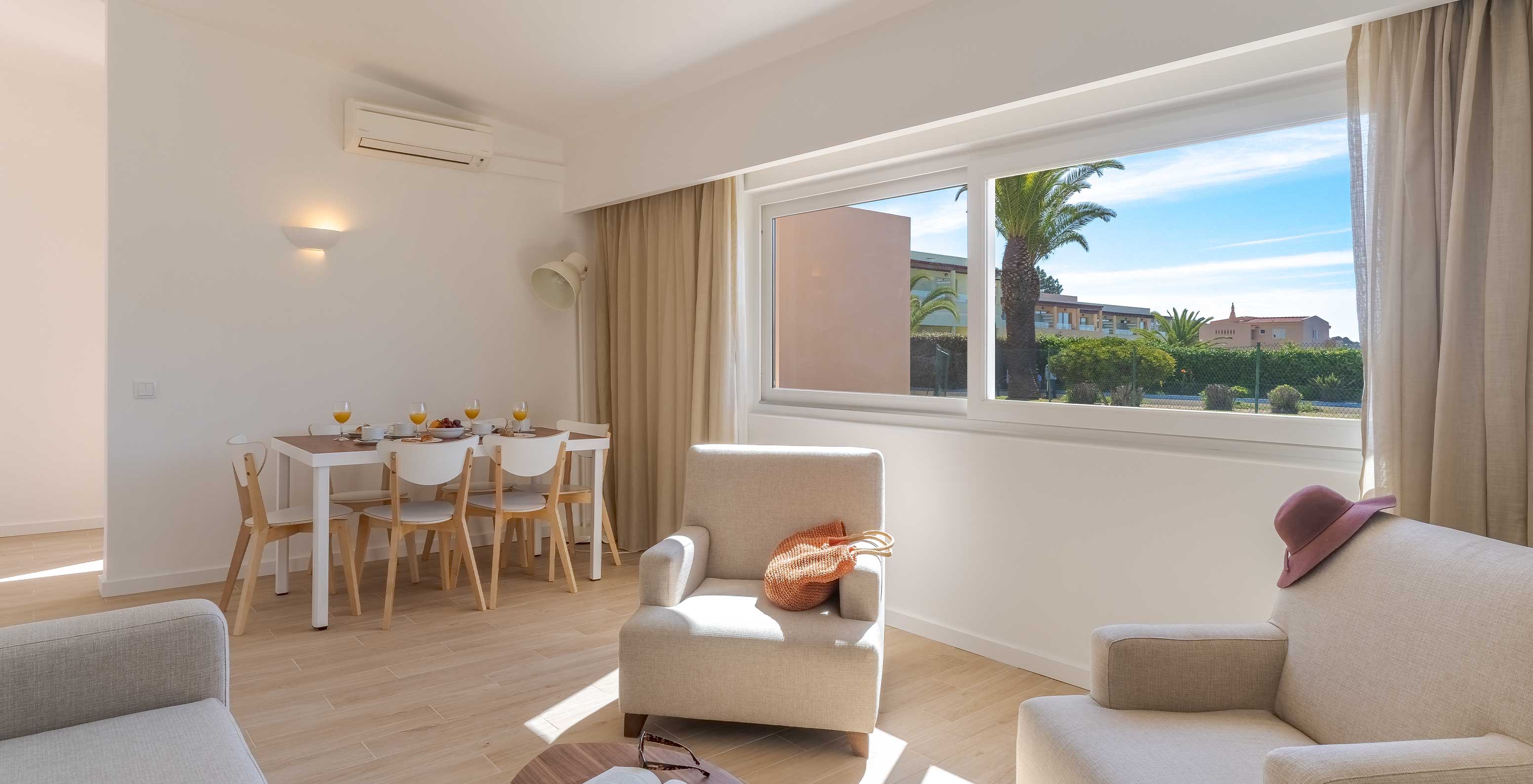 De Villa 3 Kamer met uitzicht op de tuin van Pestana Alvor Beach Villas heeft een woonkamer met fauteuils en tafel