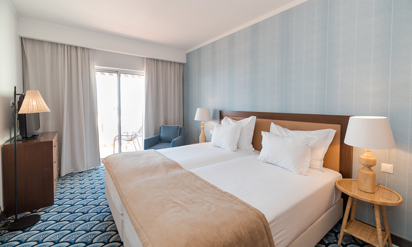 Appartement T1 Zeezicht bij Pestana Alvor Beach Villas heeft kamer met twee bedden, bank en raam met balkon