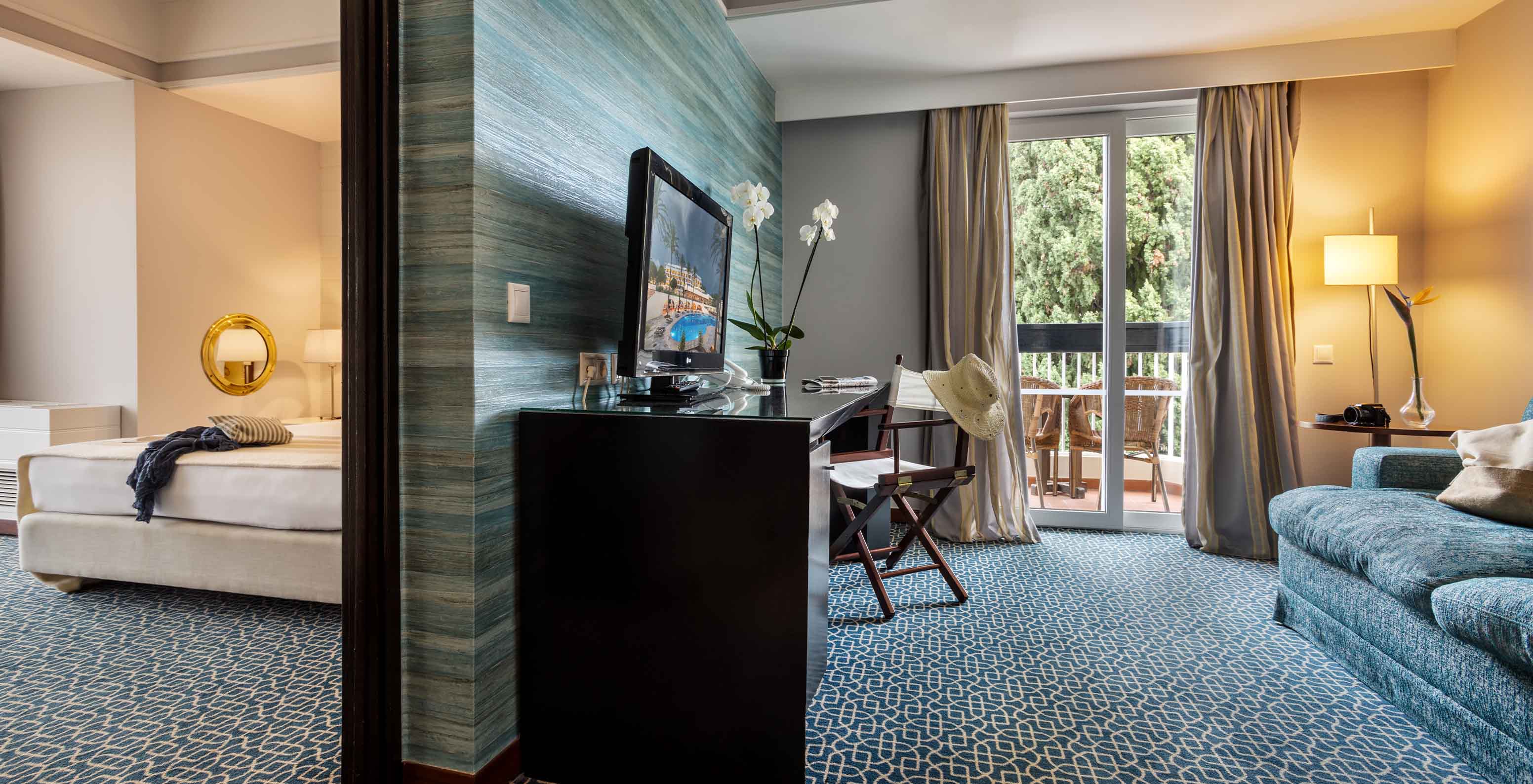 De Suite met uitzicht op de tuin van Pestana Alvor Praia heeft een ruimte met bank, bureau en televisie en slaapkamer met bed